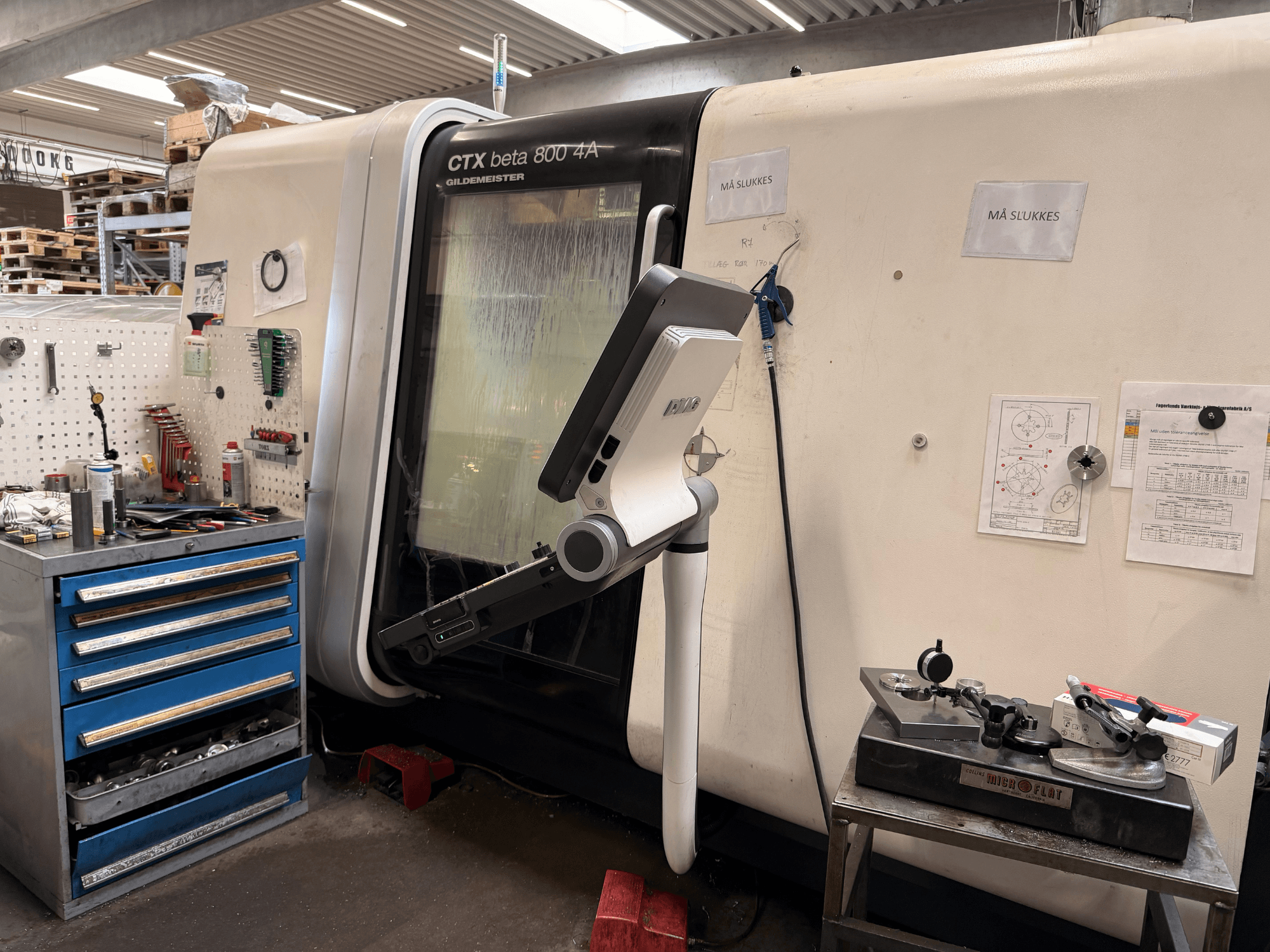Вертикальний токарний верстат DMG MORI CTX Beta 800 4a у майстерні, поруч - пульт керування та технічна документація.