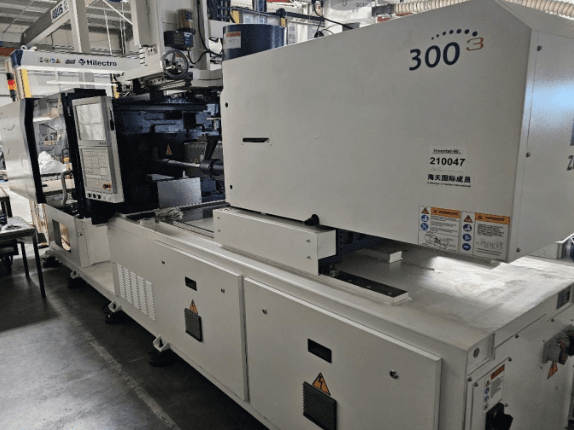 Термопластавтомат марки Zhenjing, модель 300, вид спереду з панеллю керування та попереджувальними написами про безпеку.