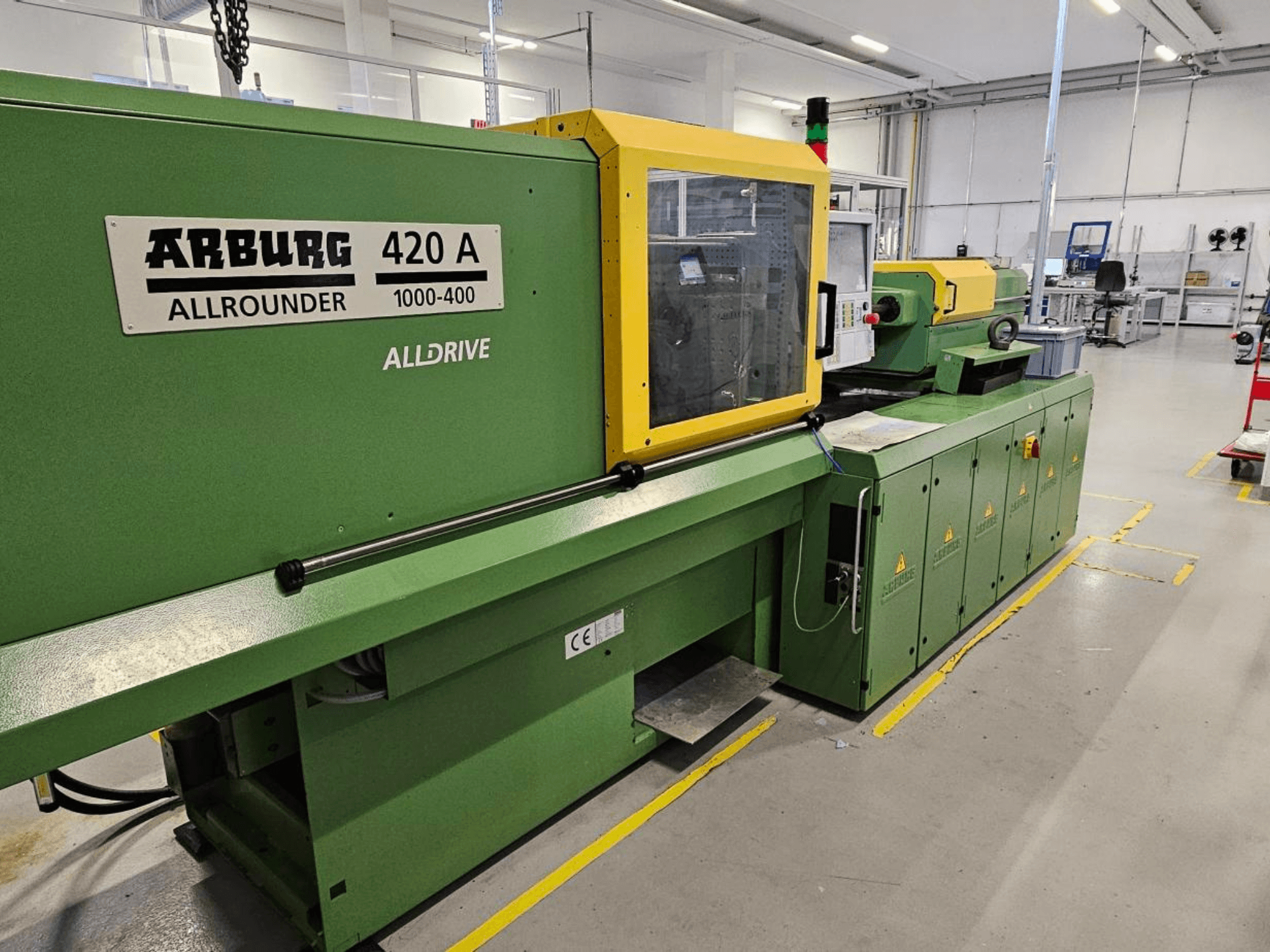 ARBURG 420 A Allrounder 1000-400, вид спереду; зелена машина з жовтою панеллю, сенсорним екраном і функціями безпеки.