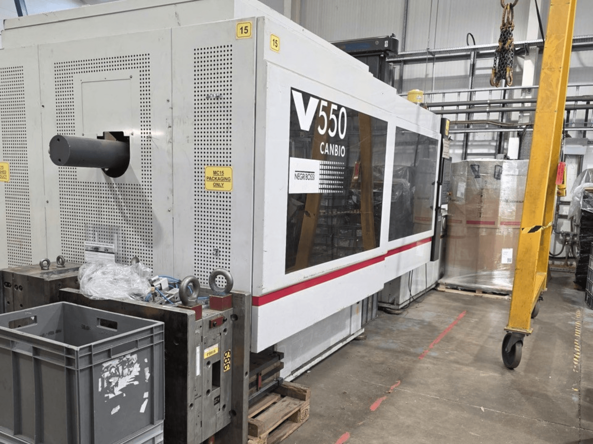 Гідравлічний термопластавтомат Negri Bossi V55000H-4250, вид збоку, з панеллю керування та сірими ящиками на передньому плані.