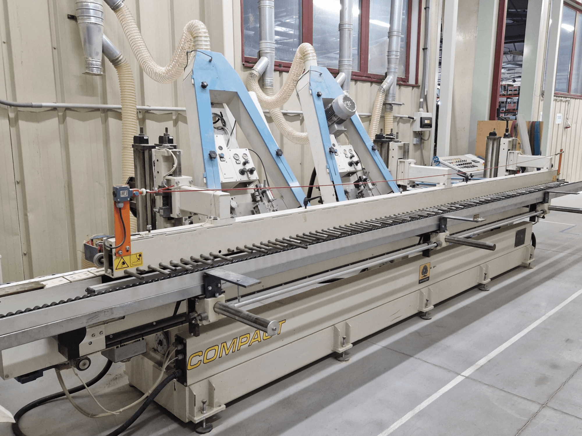 Стрічкова шліфувальна машина TECNOLEGNO COMPACT 52 в майстерні, панель керування та механізм шліфувальної стрічки збоку.