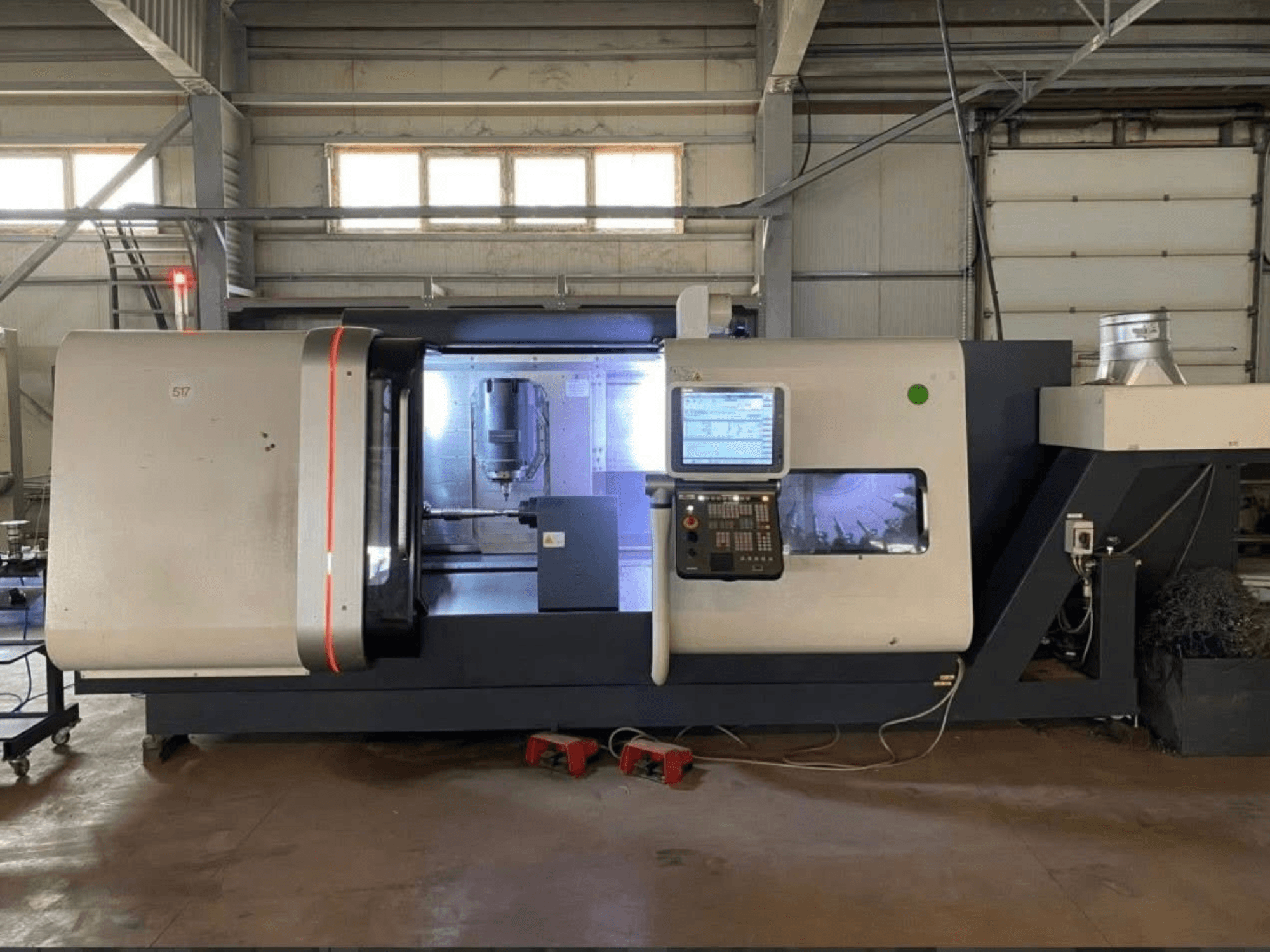 Токарно-фрезерний центр DMG MORI Beta 1250 TC, вид спереду з панеллю керування, освітленою робочою зоною та видимими ріжучими інструментами.