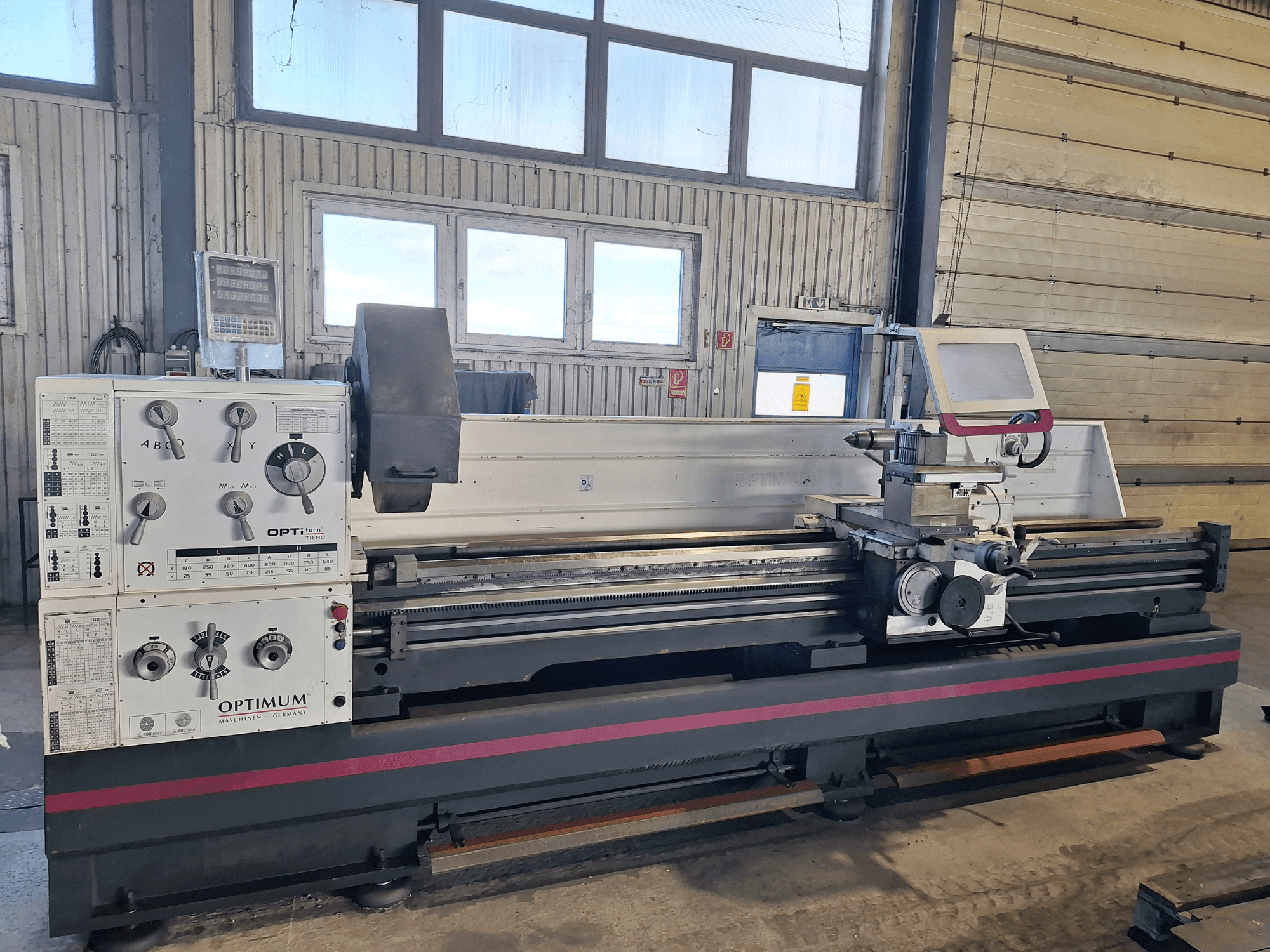 Горизонтальний токарний верстат Optimum OptiTurn TH 8030D у вигляді збоку, з панеллю керування, тримачем інструменту та міцною основою.