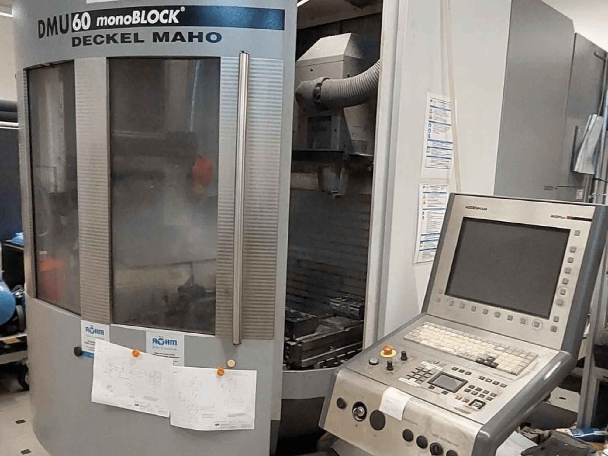 DMU 60 monoBLOCK від Deckel Maho, вигляд спереду фрезерного верстата з ЧПК з панеллю керування та технічними кресленнями.