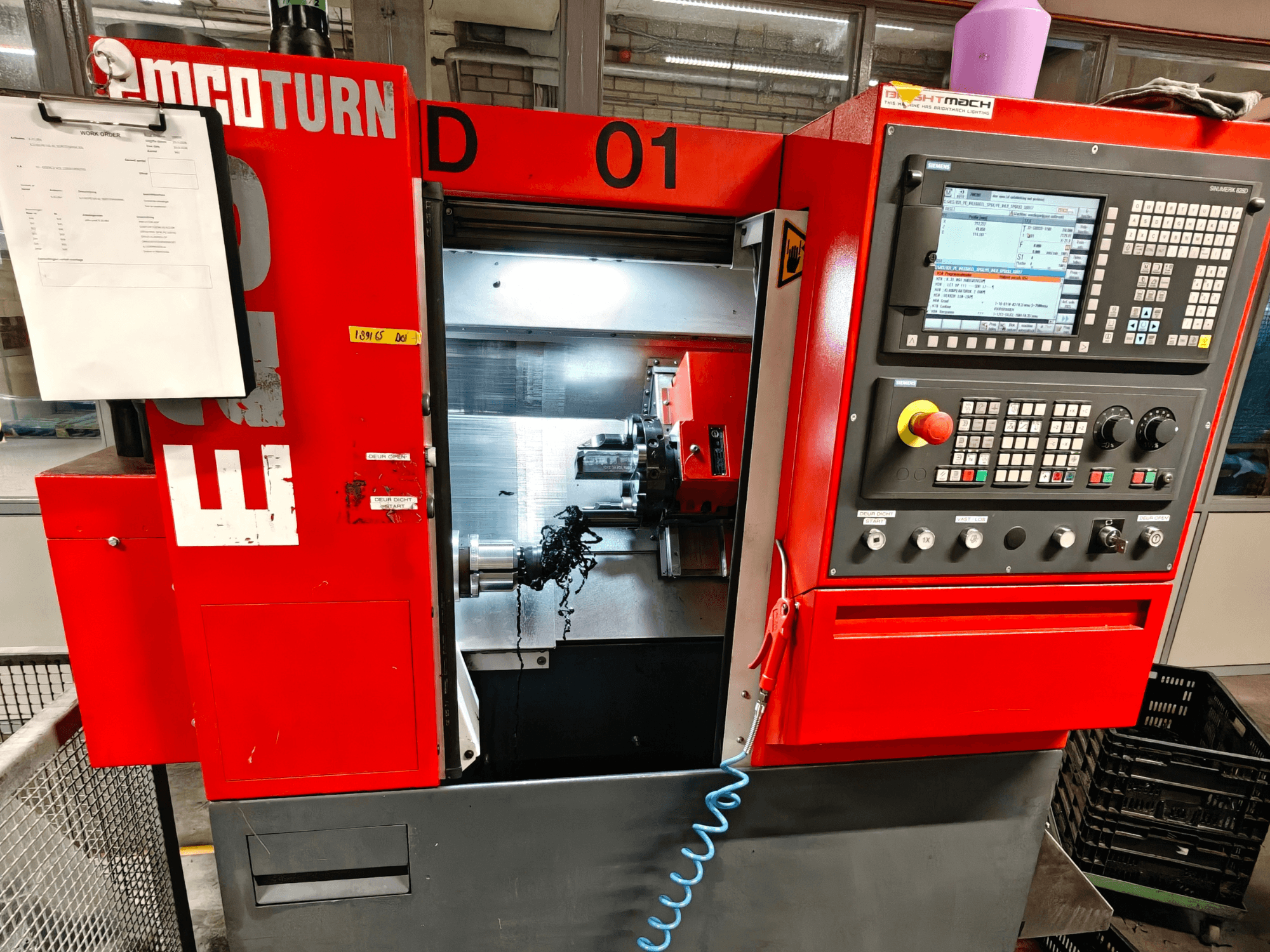 Вид спереду горизонтального токарного верстата EMCO TURN E25 з органами керування, тримачем інструменту та робочою зоною зі стружкою.