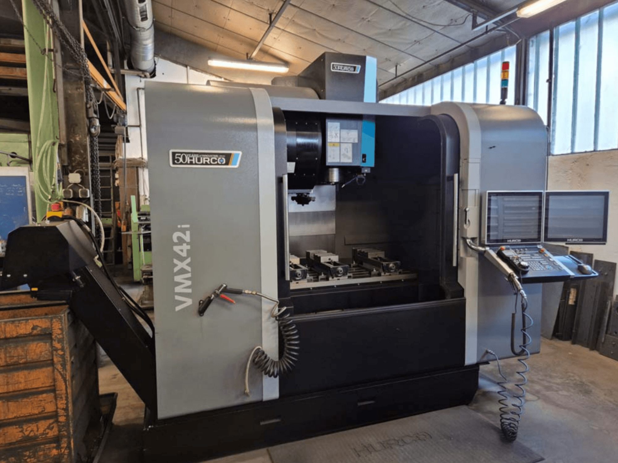 Вертикальний обробний центр Hurco VMX 42i, вид спереду, демонструє панель керування та робочу зону з лещатами.