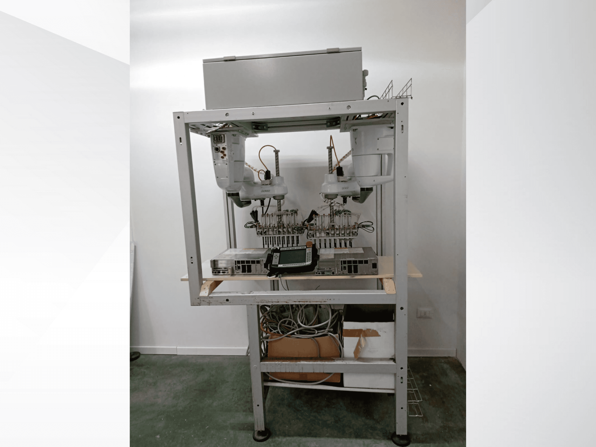 Автоматизована роботизована робоча станція з двома руками, дисплеєм та електронікою на металевій рамі, вид спереду, передова технологічна установка.