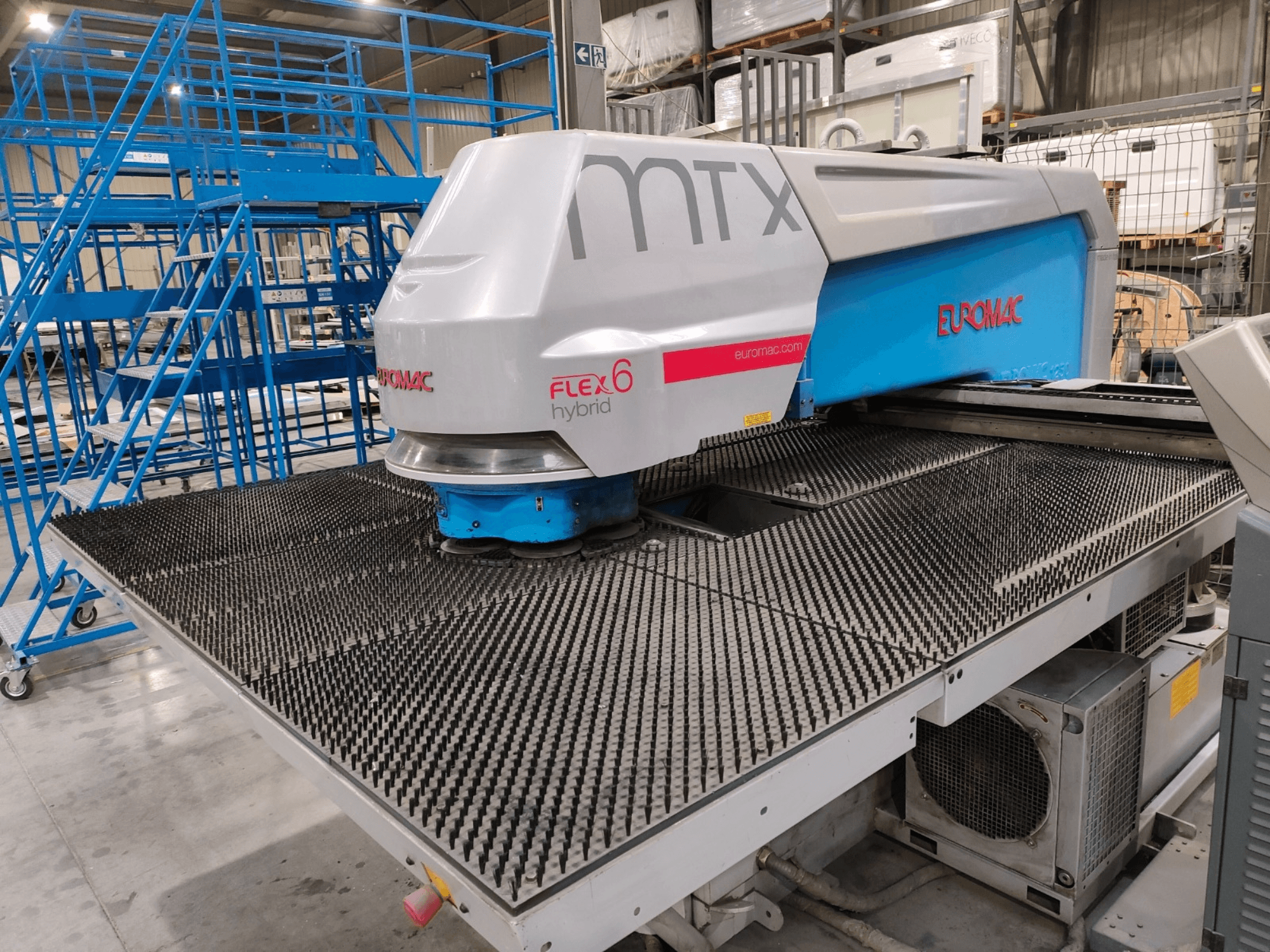 Вид спереду гібридного верстата Euromac FLEX 6 з текстурованою ріжучою поверхнею, встановленого в складських умовах.