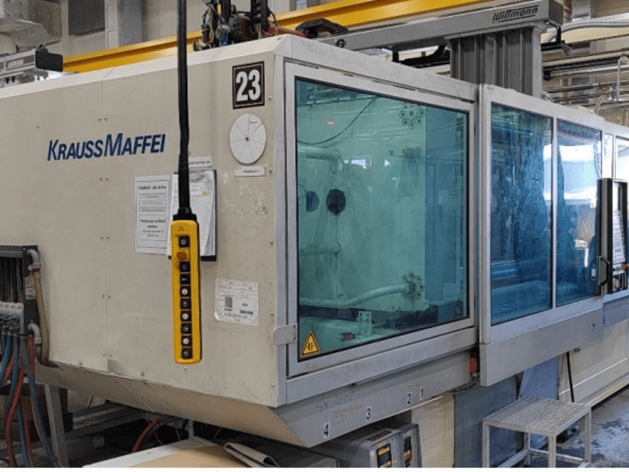 Гідравлічний термопластавтомат Krauss Maffei KM 350-1900 C2, вид спереду, на якому видно панель управління та прозорий захисний кожух.