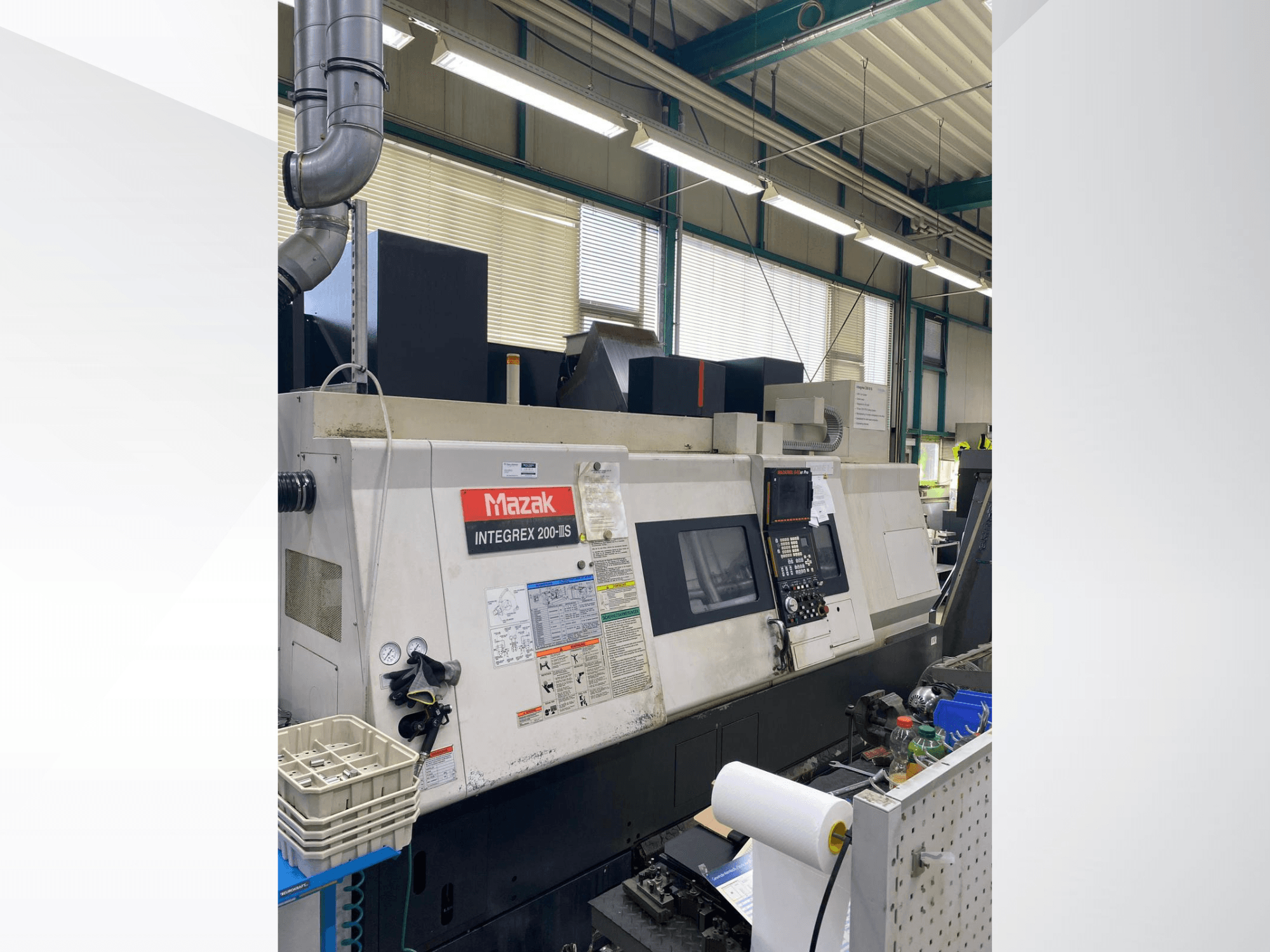 Токарно-фрезерний центр Mazak INTEGREX 200 III S, вид збоку, на якому видно панель управління, вимірювальні прилади та інструменти на робочій зоні.