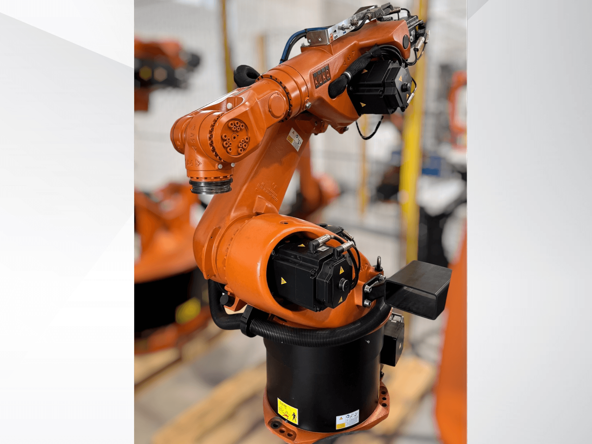 Робот-маніпулятор KUKA KR 60-3 помаранчевого кольору; вид збоку, що показує основу, шарніри та модулі керування для автоматизації завдань.