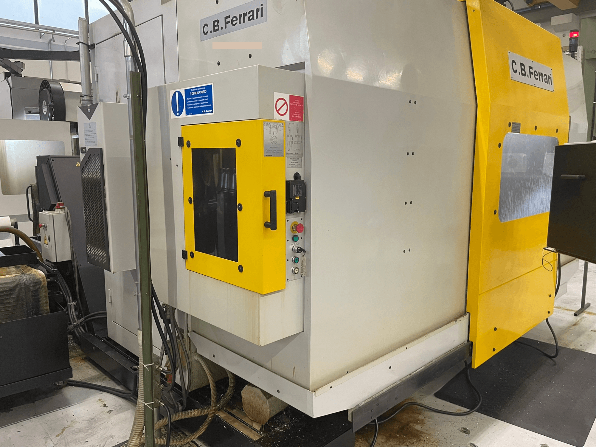 Промисловий верстат C.B. Ferrari, вид спереду; жовті двері, панель управління та видимі компоненти обробки.