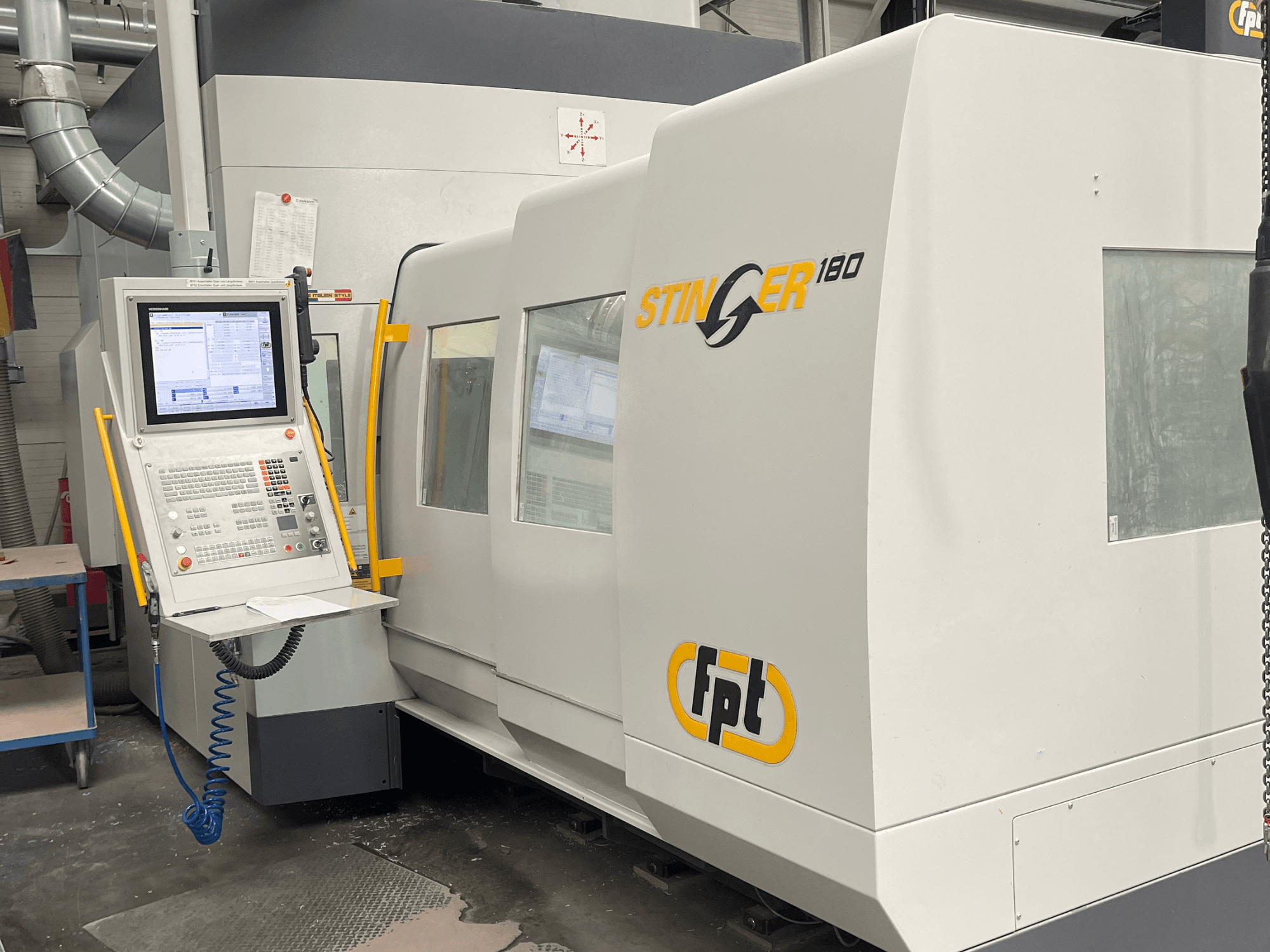 Вигляд спереду вертикального обробного центру FPT STINGER 180, на якому видно панель керування та особливості верстата.