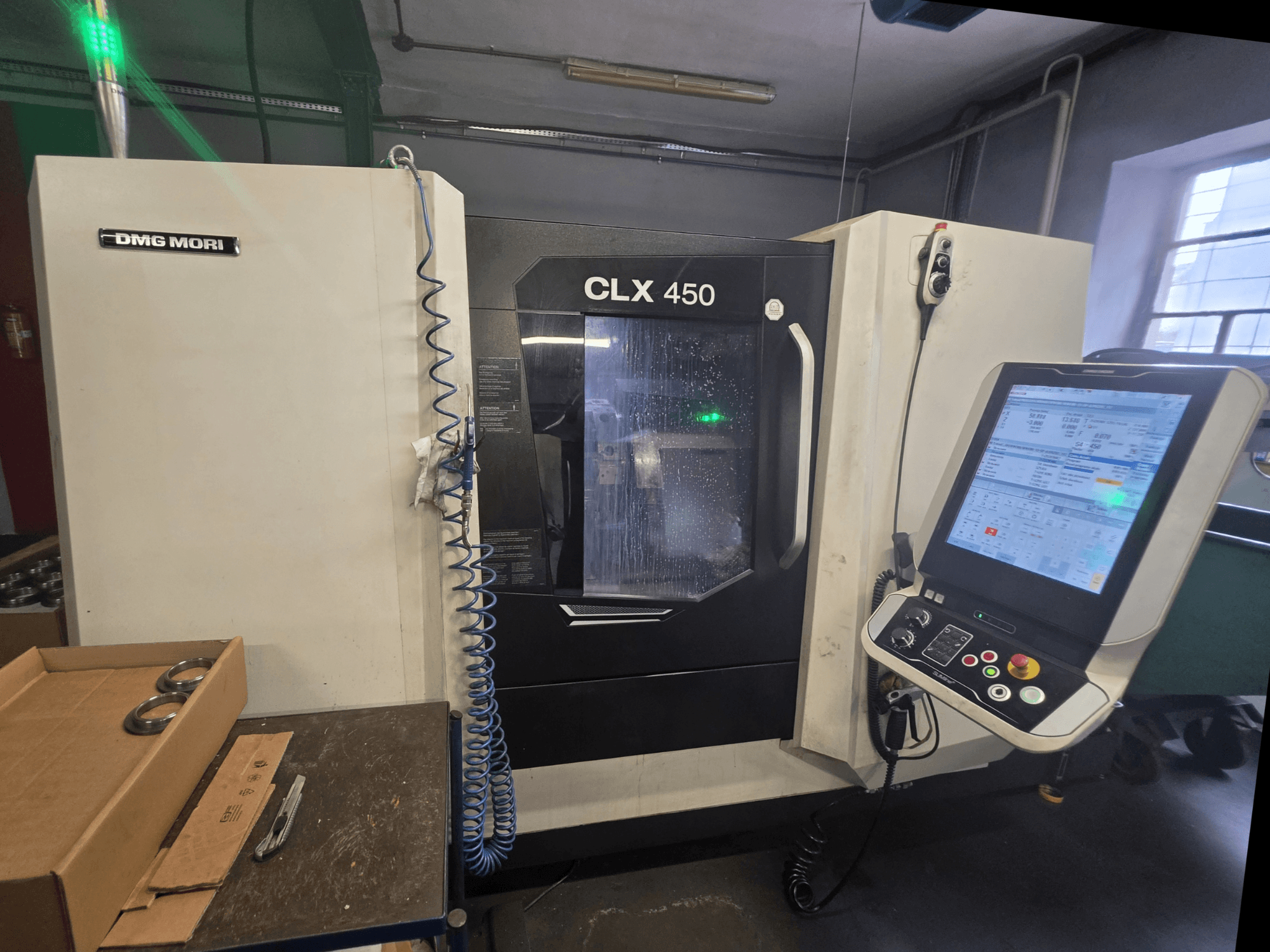 Горизонтальний токарний верстат DMG MORI CLX 450 V3 у фронтальному ракурсі: на фото зображено панель керування, систему охолодження та робочу зону.