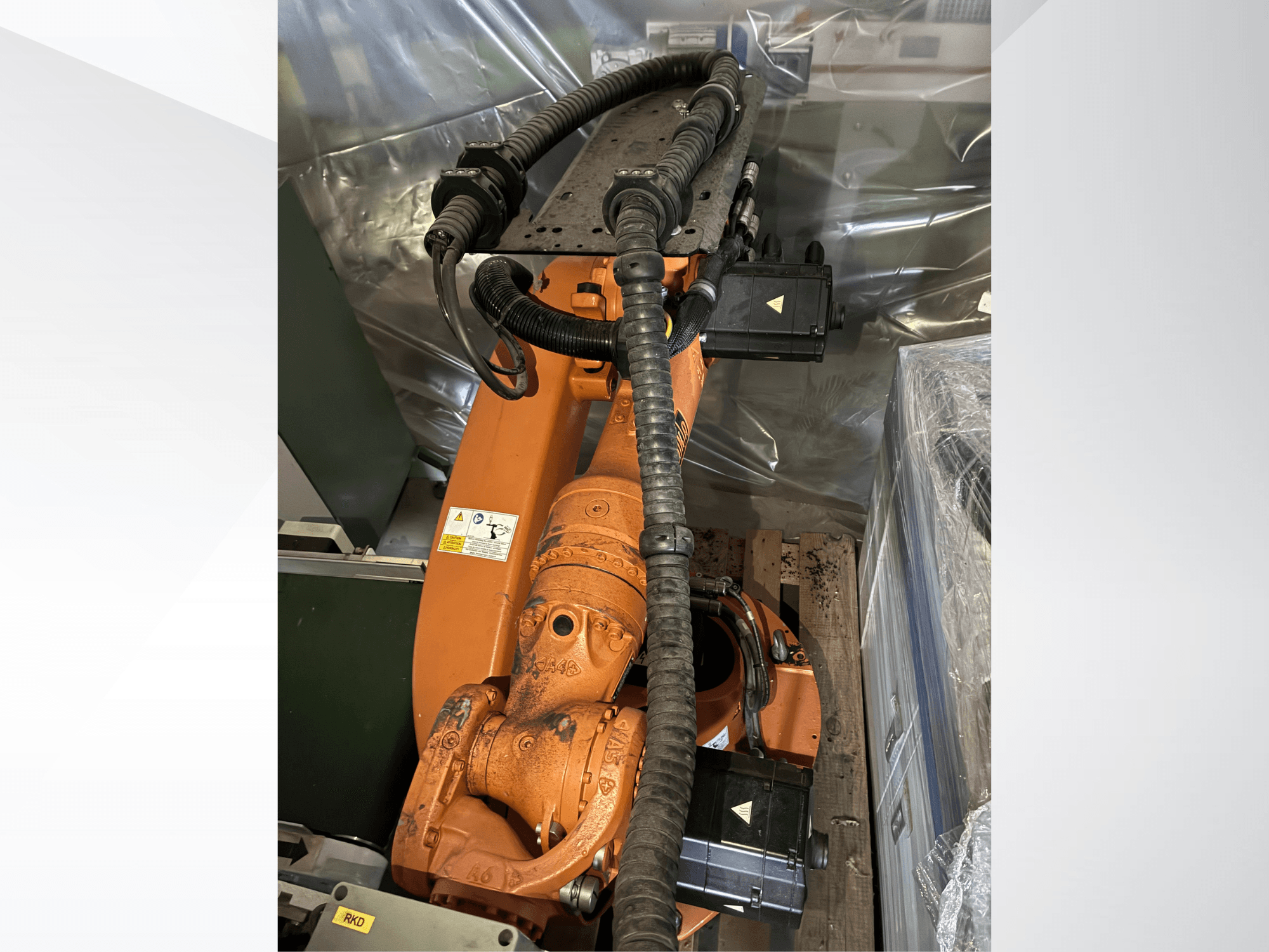 Роботизована рука KUKA KR16-2 оранжевого кольору, вид зверху, на якому видно з’єднувачі та захисні трубки.