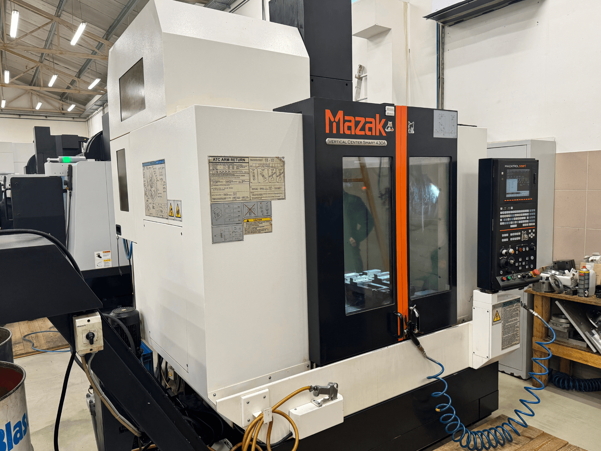 Вертикальний центр Mazak Smart 430A, вид спереду; фрезерний верстат з ЧПК, панеллю керування, прозорим корпусом і тримачем інструменту.