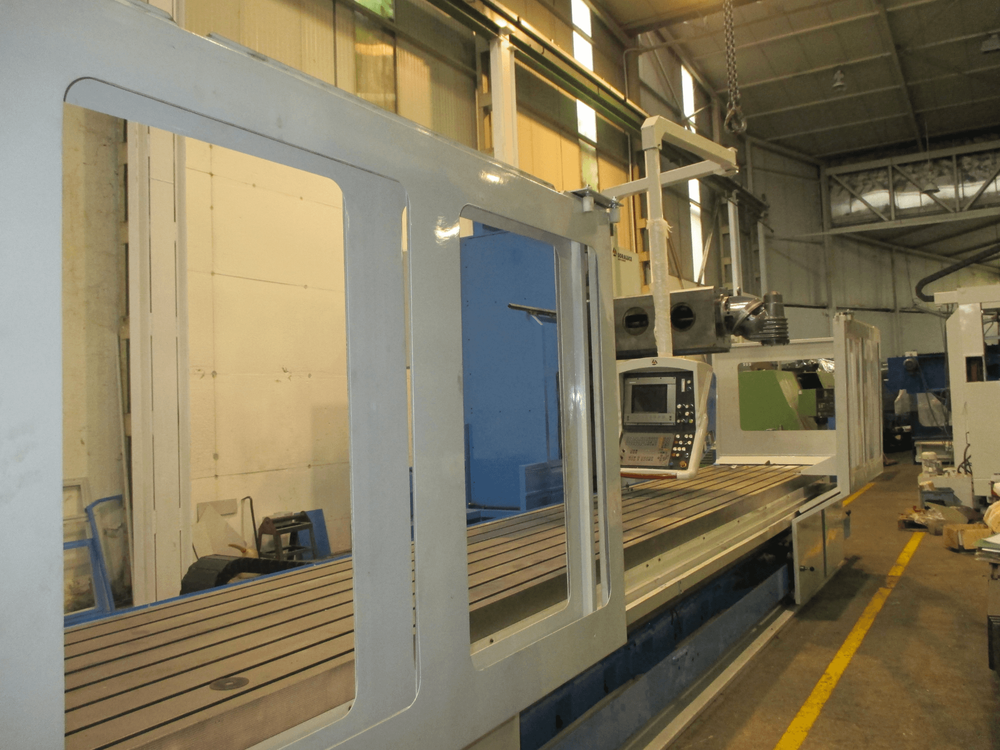 Фрезерний верстат Soraluce SM 8000 на станині у боковому ракурсі, з панеллю управління та металевою робочою поверхнею з канавками.