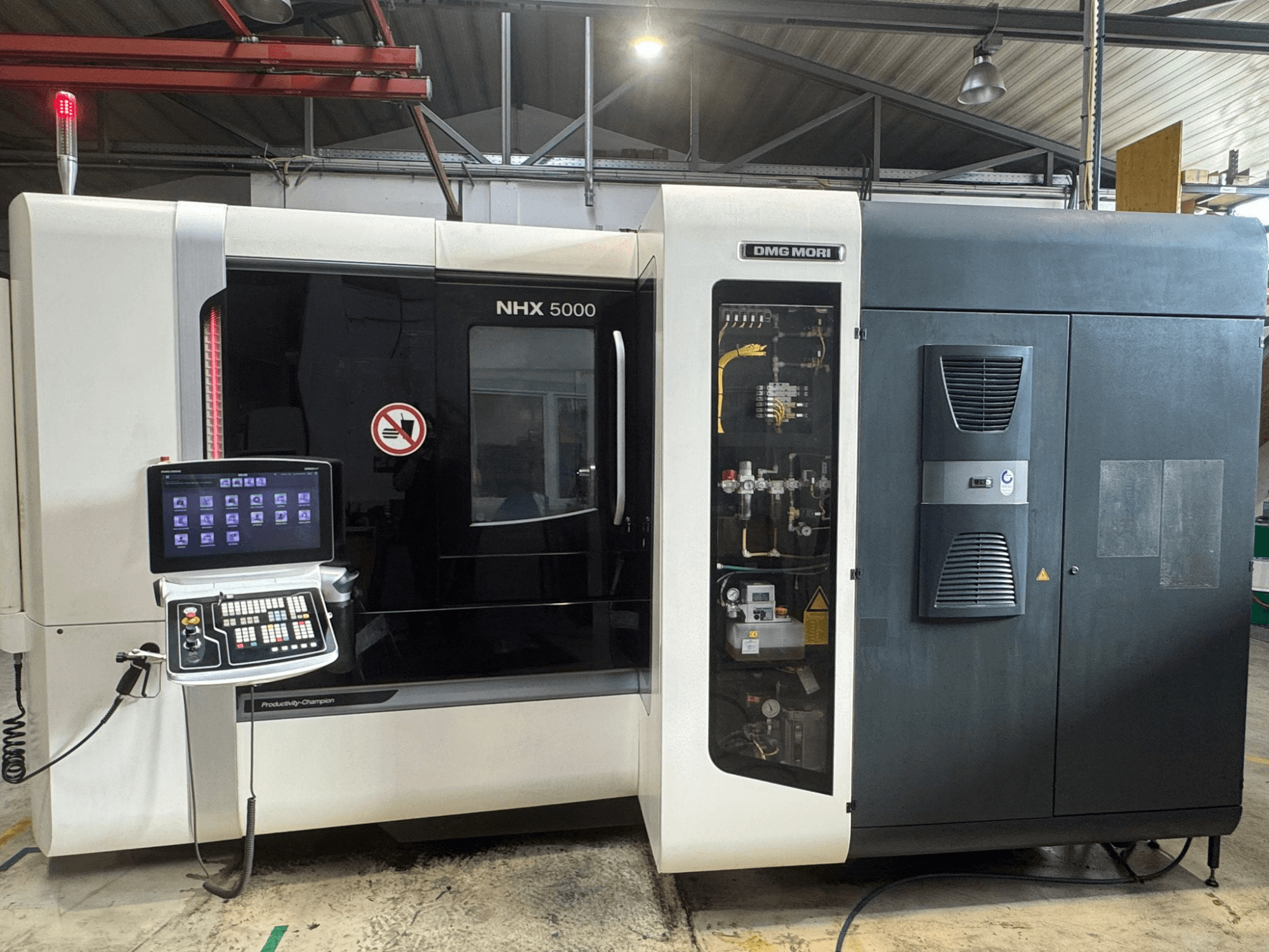 Вид спереду горизонтального обробного центру DMG MORI NHX 5000, на якому показана панель керування та деталі верстата.