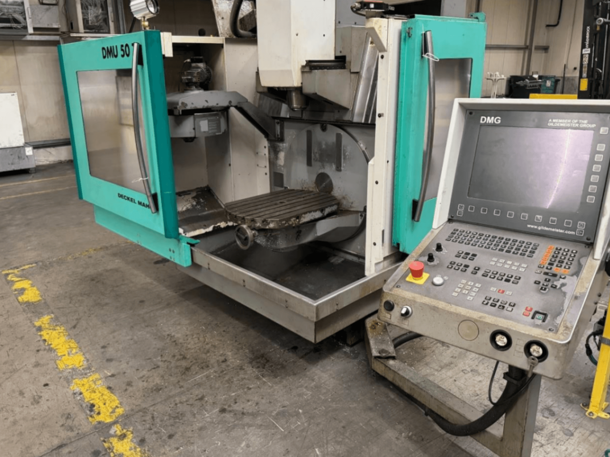 Фрезерний верстат DMG DMU 50 з відкритими дверима, що демонструють інтер'єр і панель управління, вид спереду.