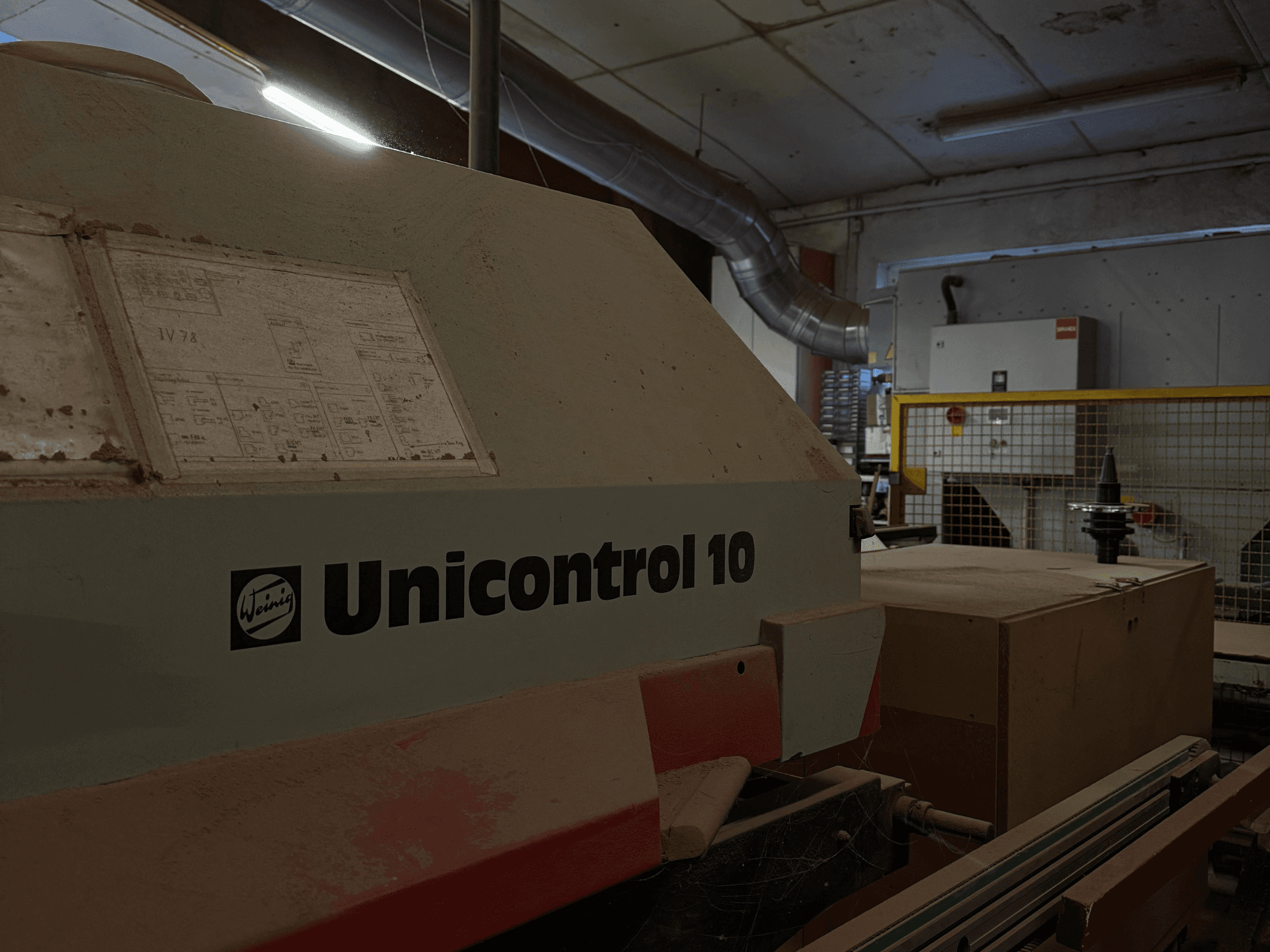 Верстат Weinig Unicontrol 10 збоку, запилена поверхня, на передній панелі видно технічні схеми.