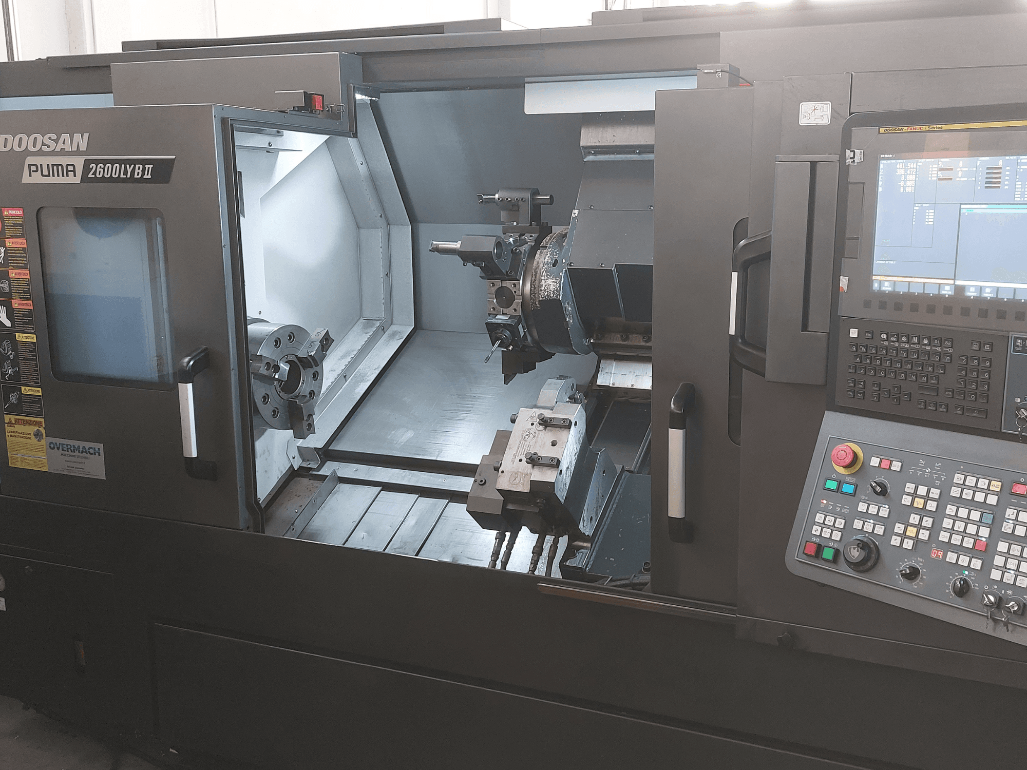 Горизонтальний токарний верстат DOOSAN Puma 2600 LYB II, вид спереду, демонструє внутрішню частину з патроном, тримачем інструменту та панеллю керування.