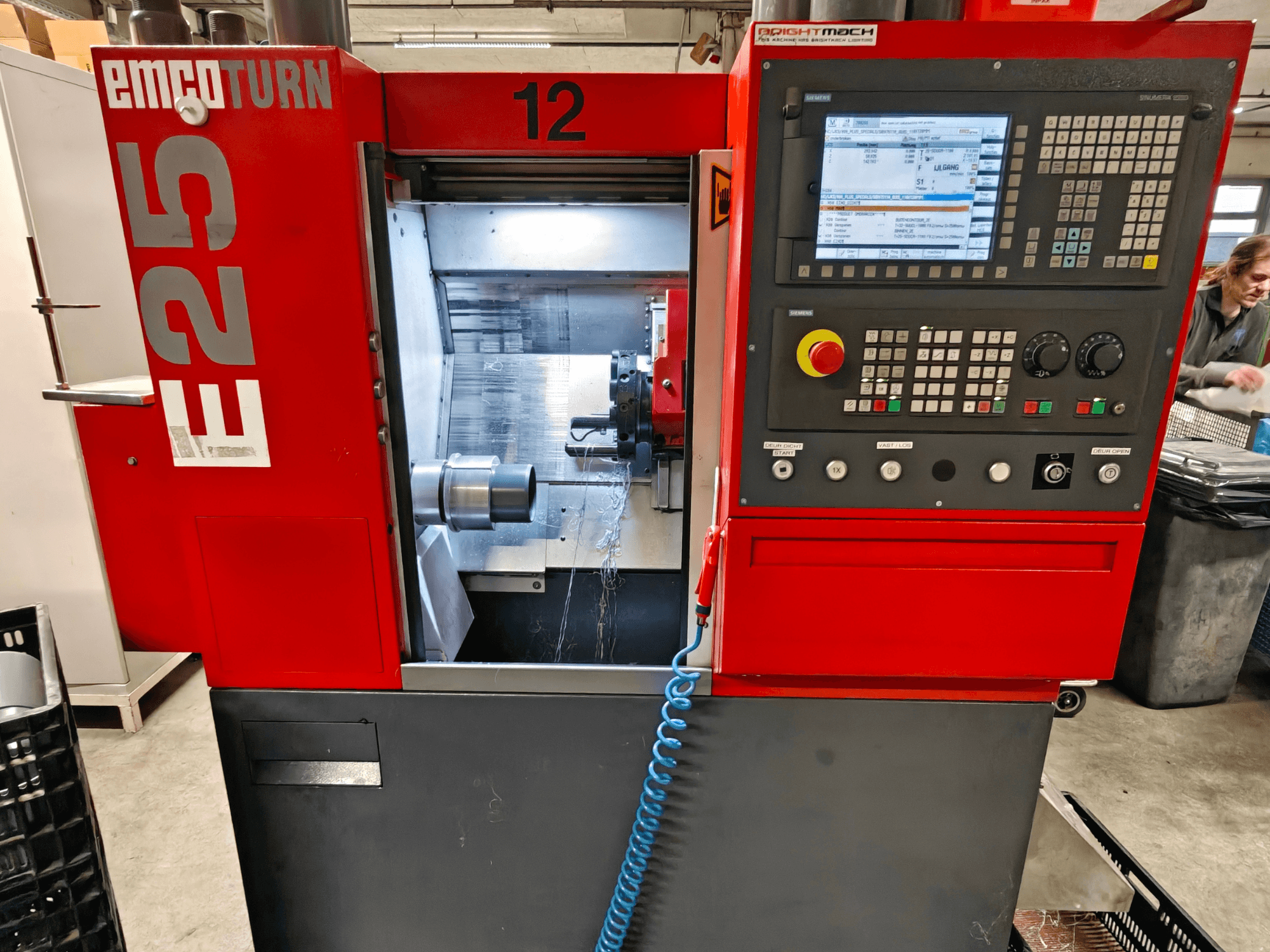 Вид спереду верстата EMCO TURN E25, з панеллю керування, тримачем інструменту та внутрішньою зоною, де видно ріжучий інструмент.