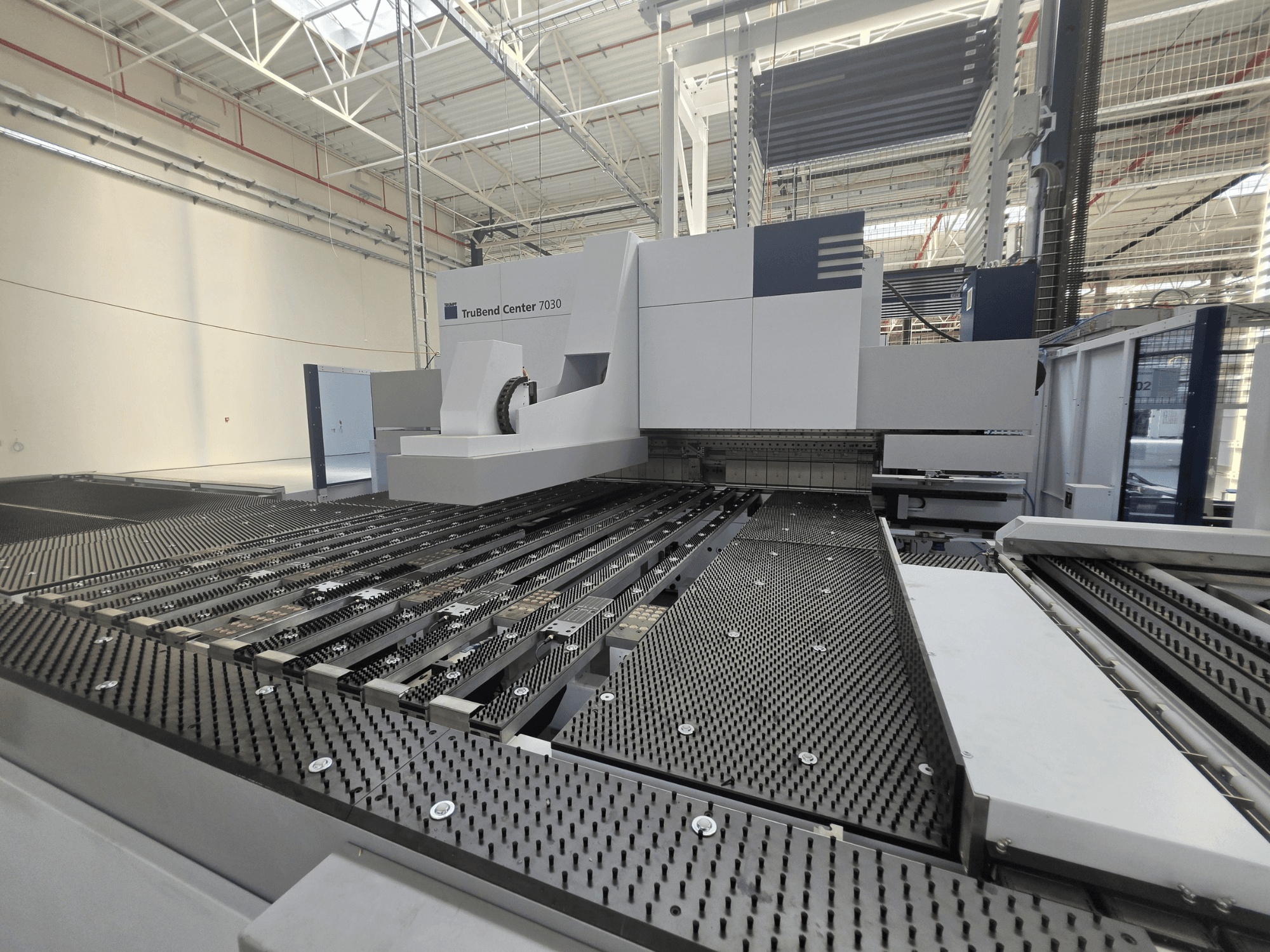 Гнучкий верстат TRUMPF TruBend Center 7030 у заводській комплектації, вид спереду, на якому видно складну конструкцію робочого столу та гнучкого важеля.