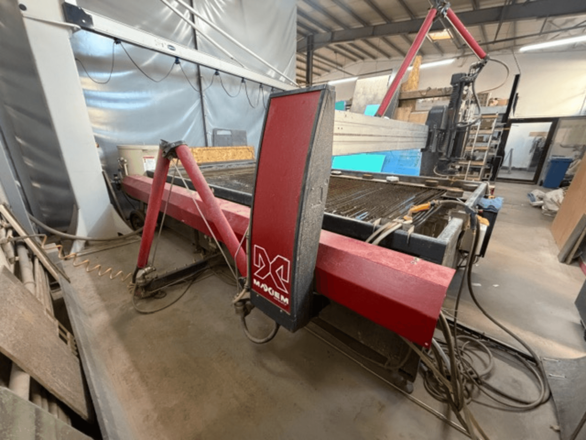 Червона машина гідроабразивного різання марки X, вид збоку, показує механічні компоненти та деталі трубопроводів.