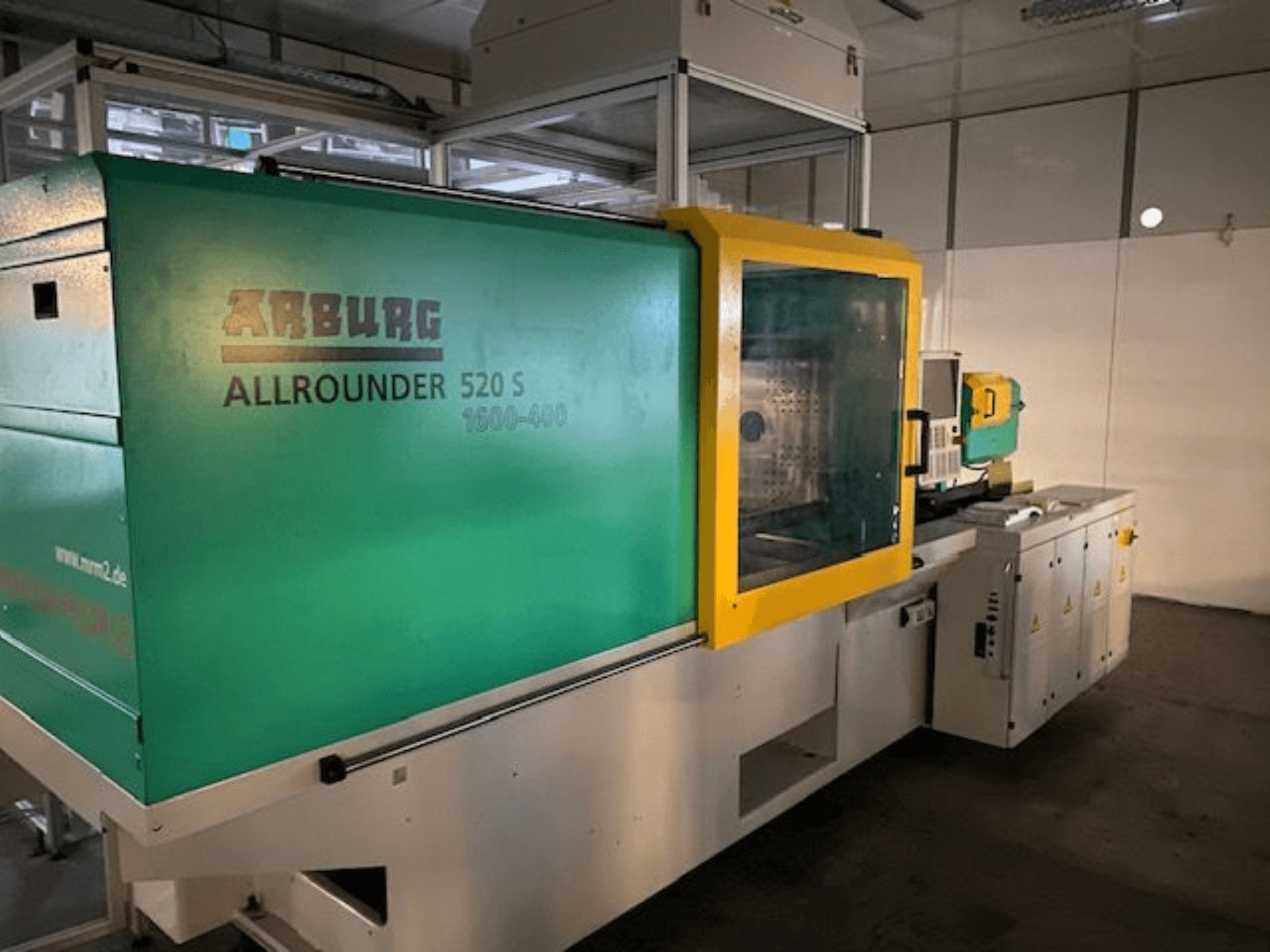 Термопластавтомат Arburg Allrounder 520 S, вид збоку, із зелено-жовтим зовнішнім виглядом, видно технічні деталі.