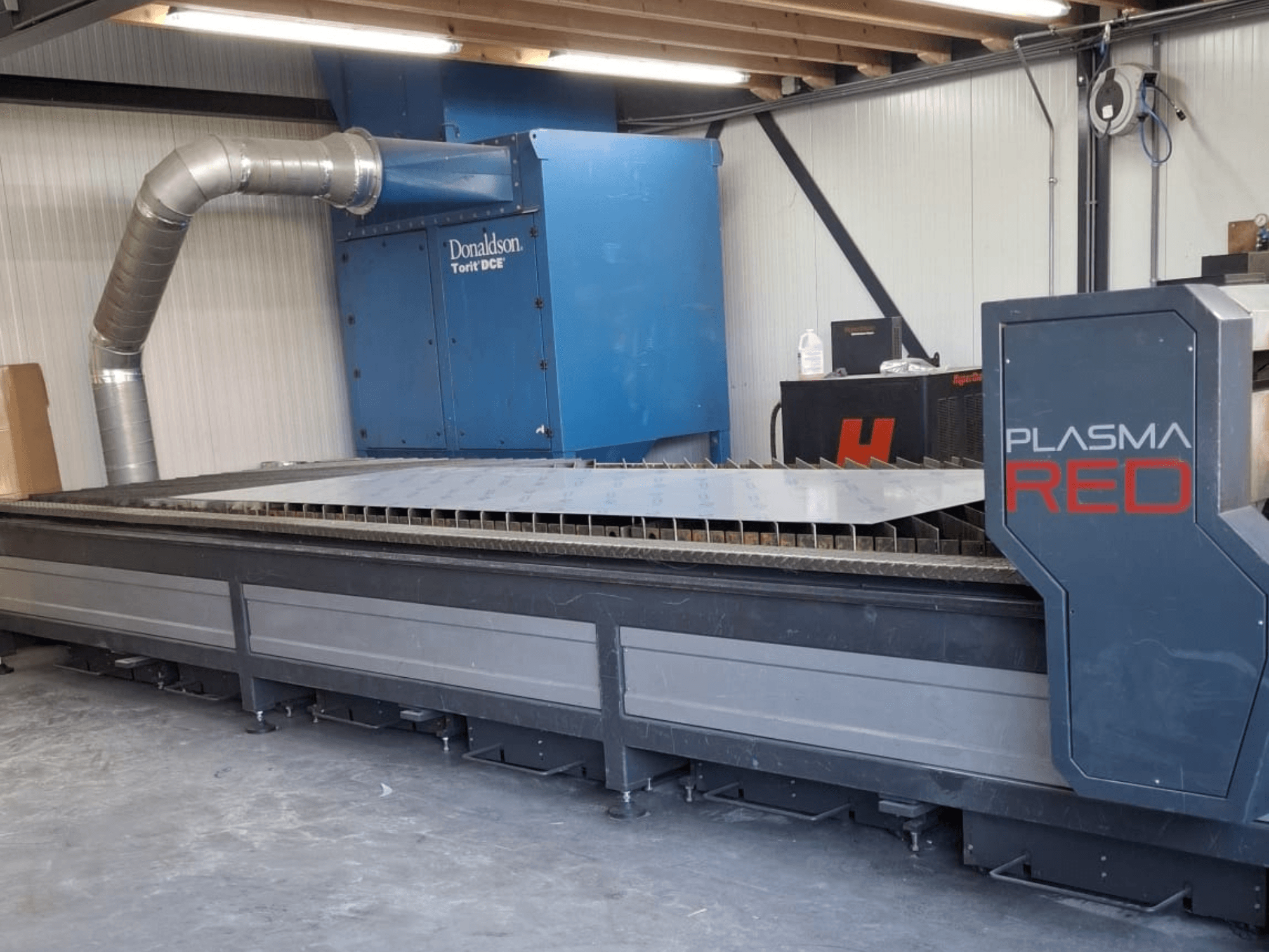 Машина для плазмового різання SOITAAB Plasmatech-Red спереду, з широким столом для різання та вихлопною системою.