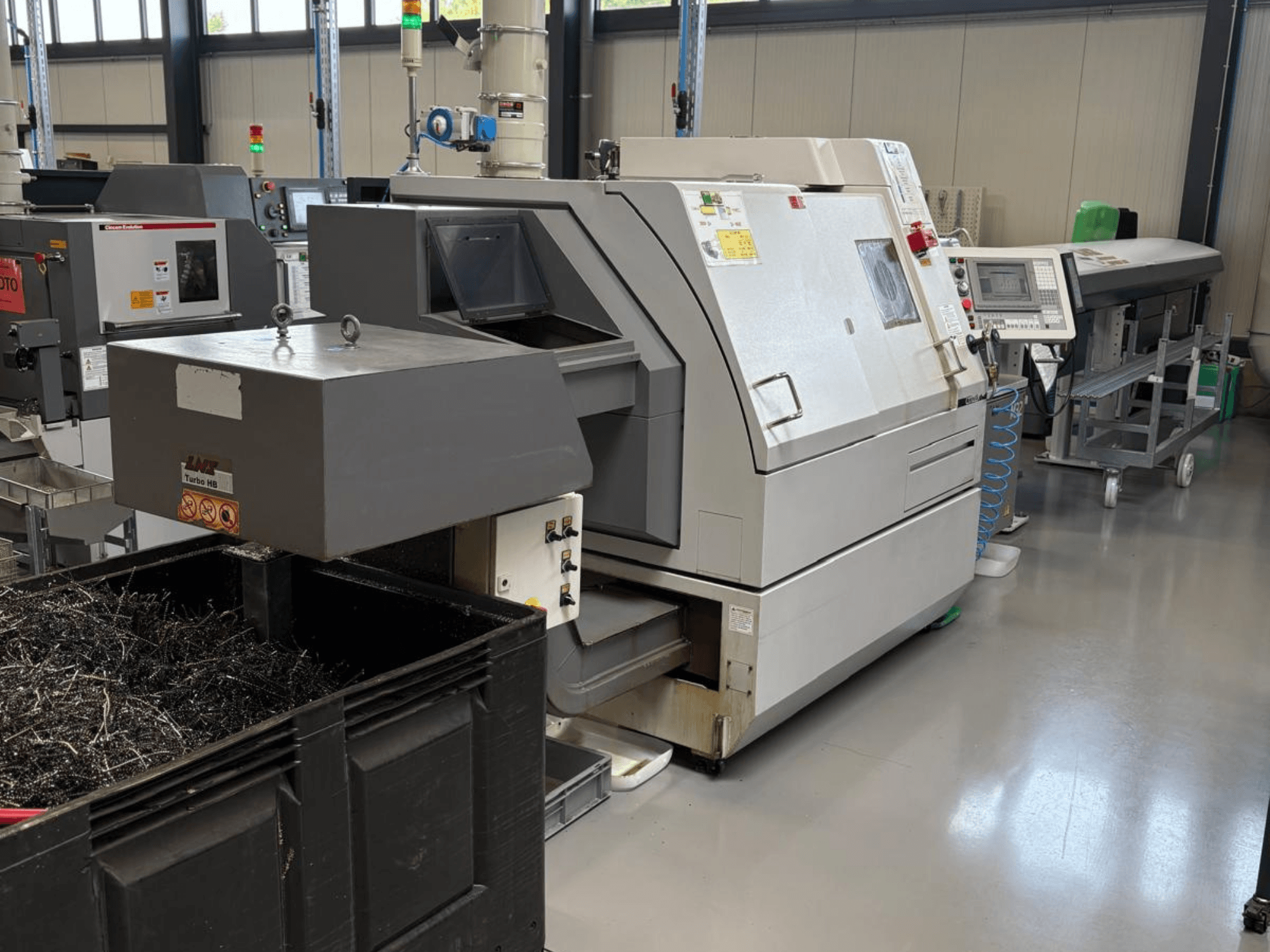 Промисловий верстат LTA Turbo H8, вид збоку, з великим контейнером для металевої стружки і панеллю керування в заводському виконанні.