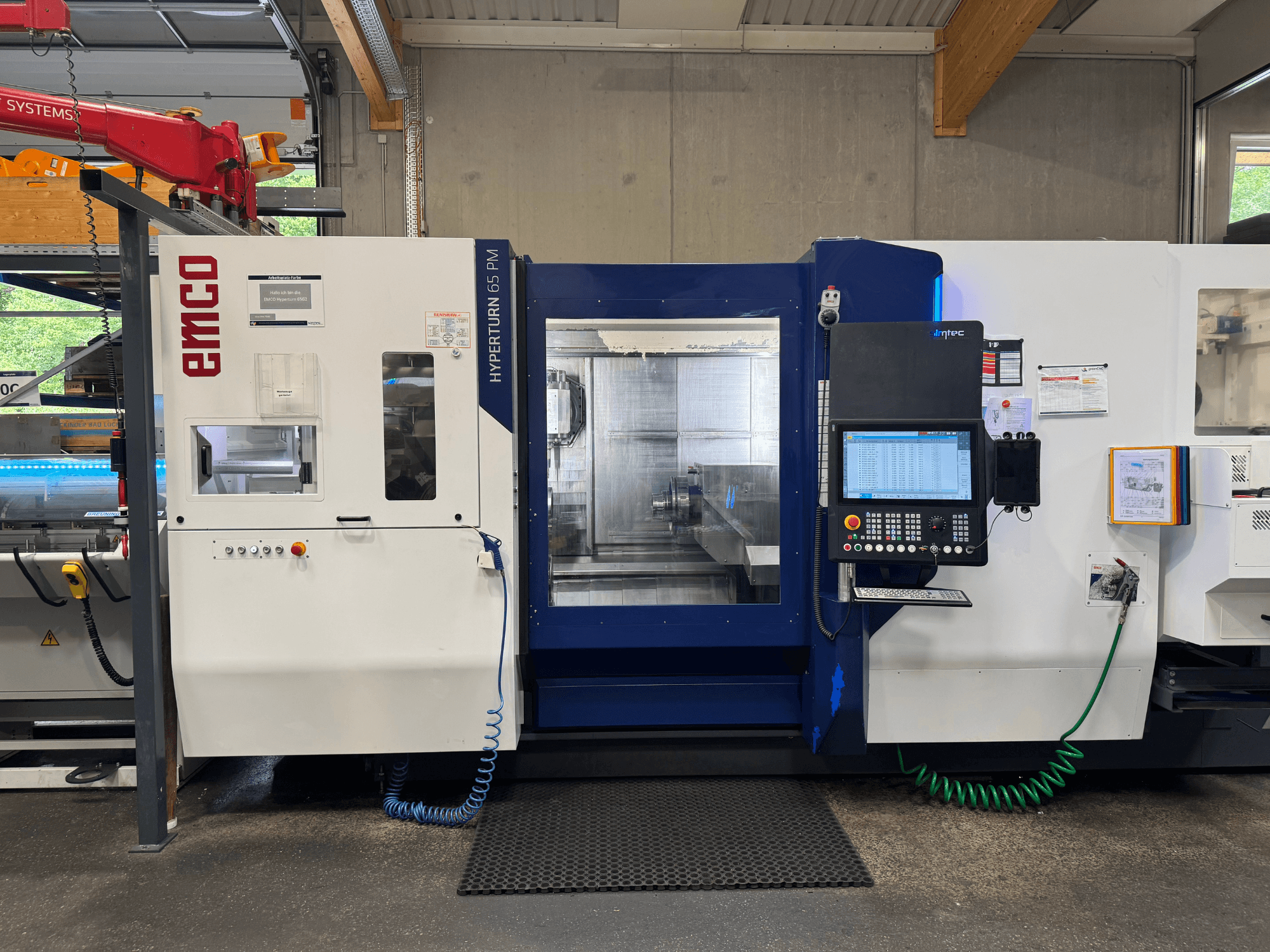 Верстат EMCO Hyperturn 65 PM, вид спереду, показує панель управління, зону шпинделя та робочі функції.