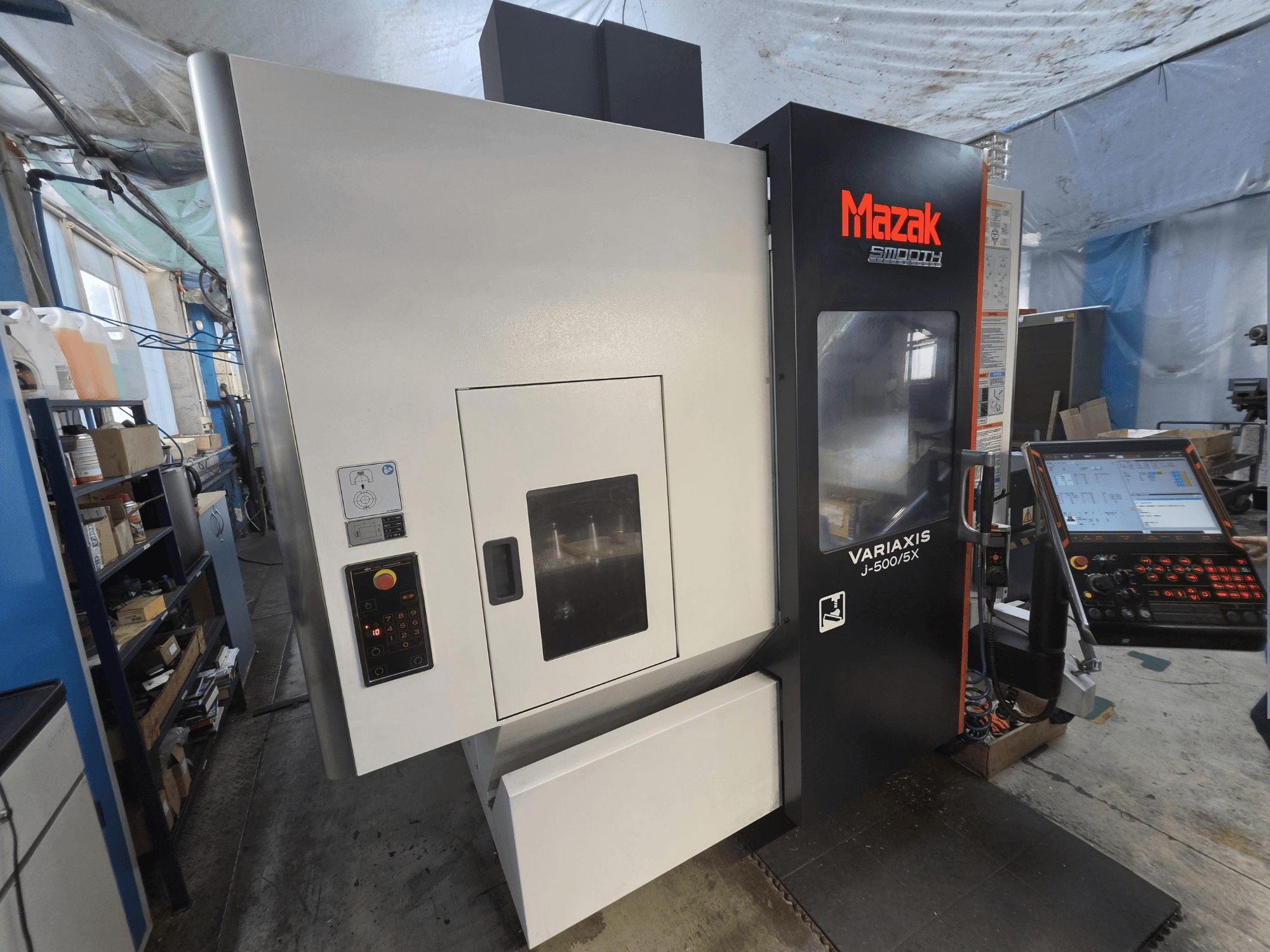 Вертикальний обробний центр Mazak VARIAXIS J-500/5X у фронтальному ракурсі, з панеллю керування та великим оглядовим вікном обробної зони.