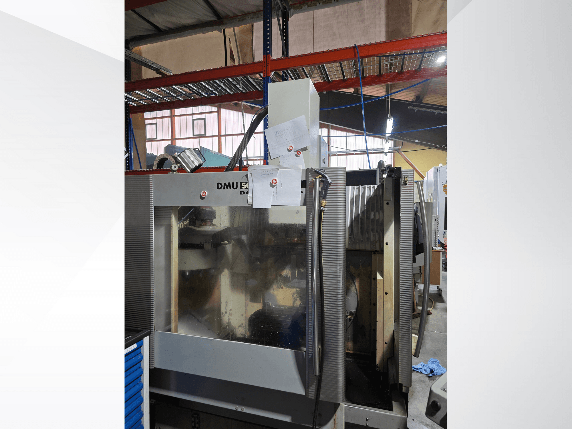 3-осьовий обробний центр з ЧПК DMU 50 в майстерні, показаний спереду, з робочими компонентами і доданими документами.