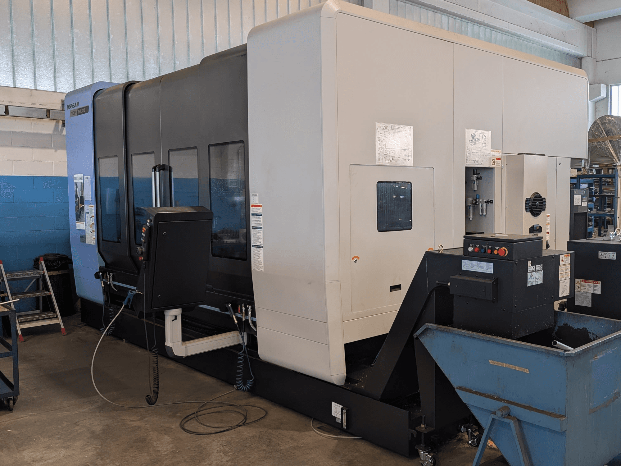 Вертикальний обробний центр DOOSAN VCF850LSR-II у боковому ракурсі: на фото видно панель управління, систему охолодження та міцну конструкцію.