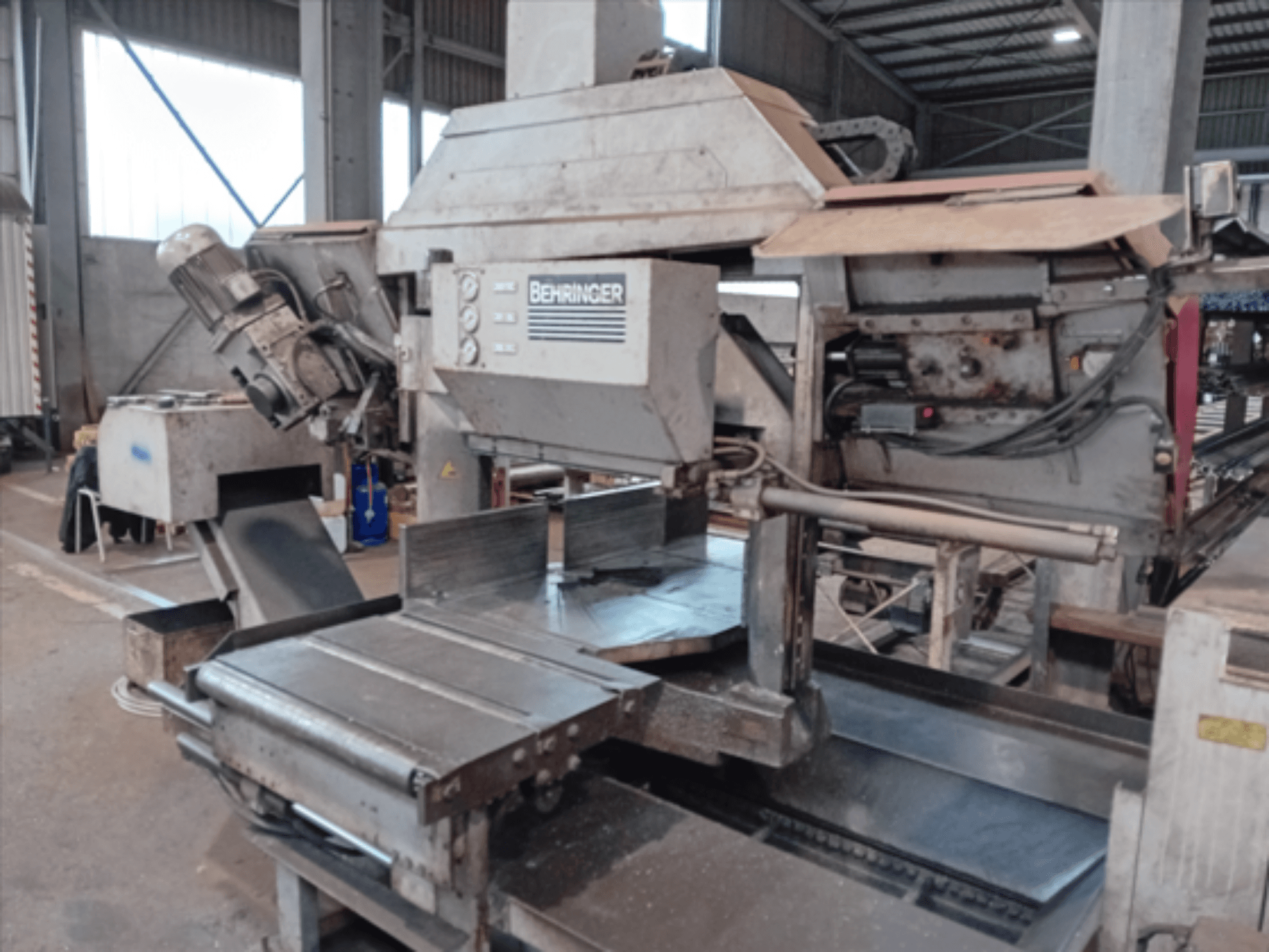 Стрічкова пила Behringer, вид спереду, має велике полотно, двигун і регульований стіл, ідеально підходить для різання металу в майстерні.