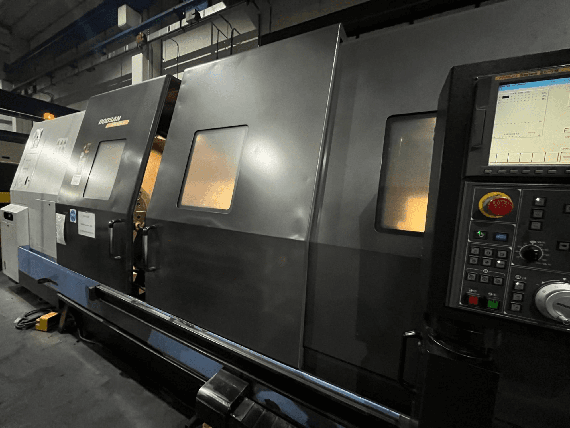 Токарний верстат з ЧПК Doosan, вид спереду, з панеллю керування та інтерфейсом оператора з видимим цифровим дисплеєм і кнопками.