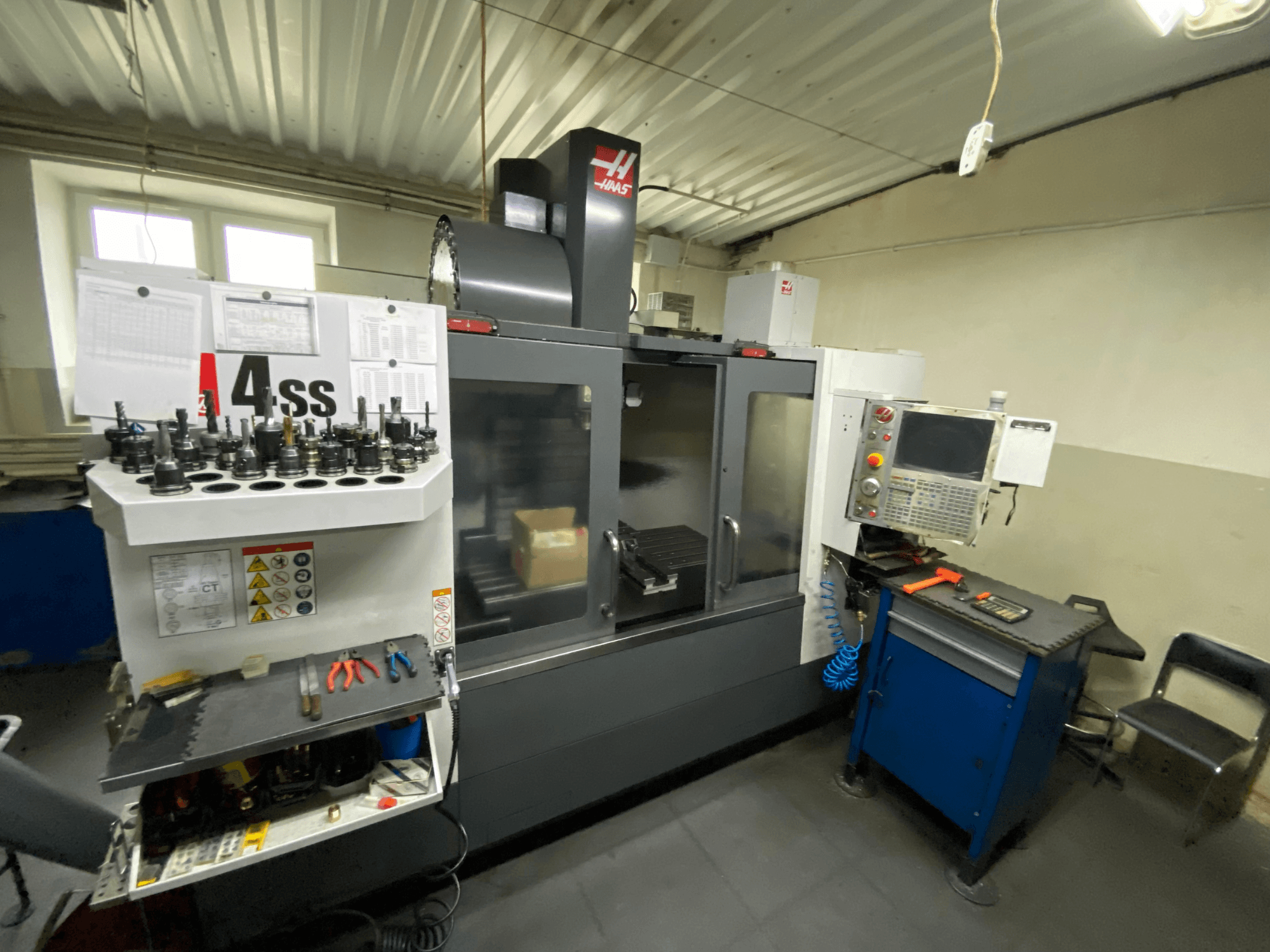 Вертикальний обробний центр Haas VF-4SS, вид спереду з тримачами інструментів та панеллю керування. На фото видно інструменти та робочу зону.
