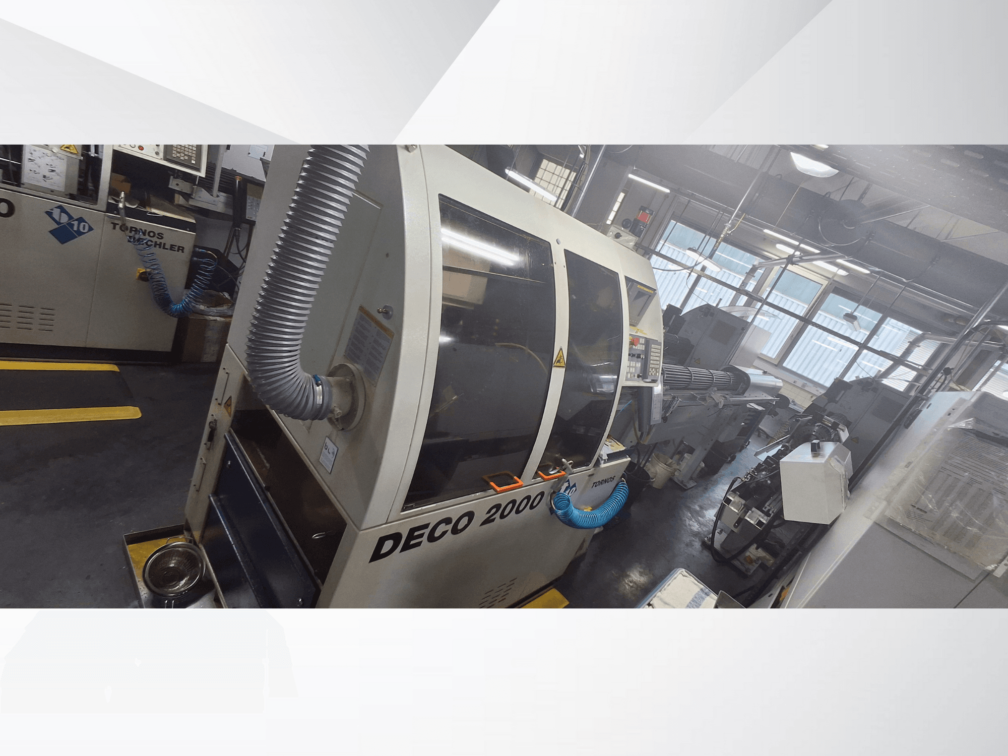 Верстат з ЧПУ DECO 2000 в майстерні, вид спереду, з вентиляційним шлангом і панеллю керування, призначений для точної обробки.