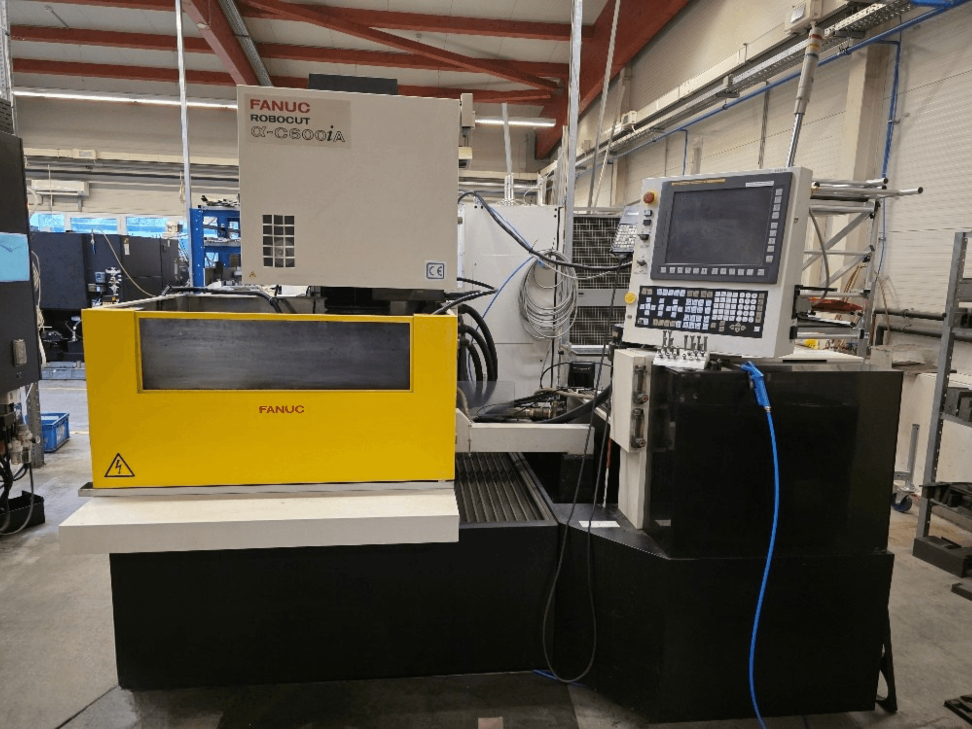 Машина для дротяного різання FANUC Robocut α-C600iA, вигляд спереду, з жовтою панеллю керування та цифровим дисплеєм.