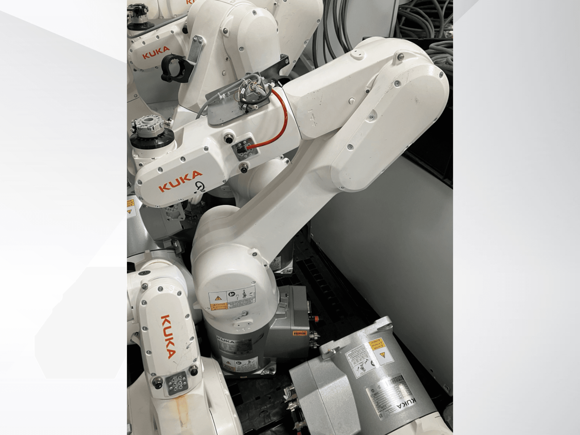 Робот-маніпулятор KUKA KR 6 R900 CR, вид збоку; видимі двигуни та роз'єми, марковані попередження про безпеку та механічні маніпулятори.
