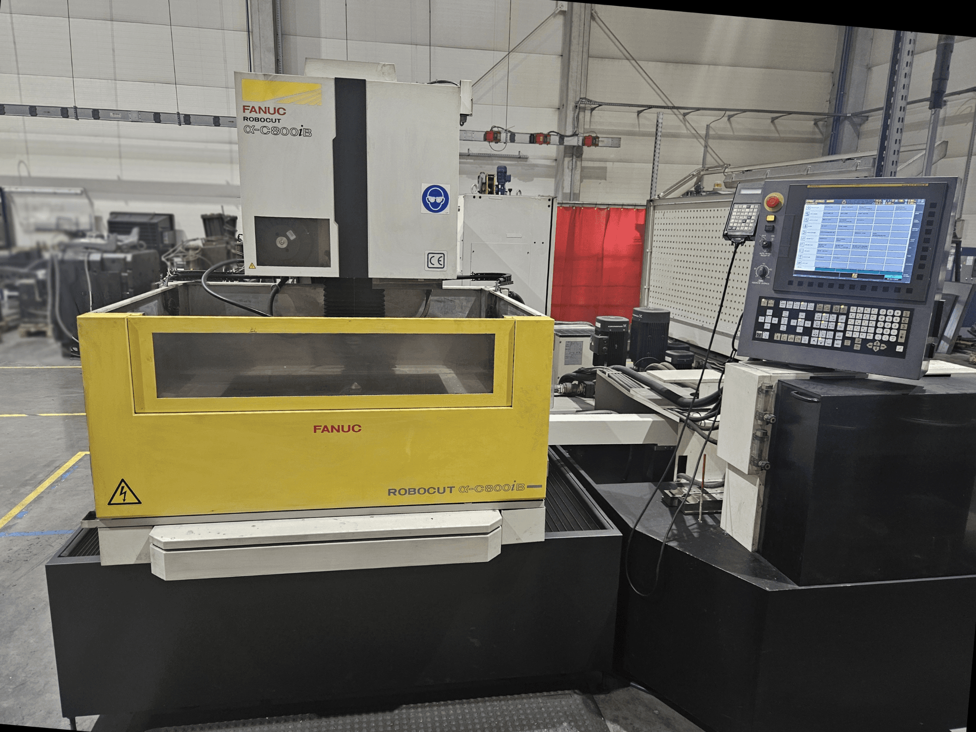 Вигляд спереду FANUC Robocut α-C600iB з жовто-сірим корпусом верстата, панеллю керування ЧПК та робочим дисплеєм.