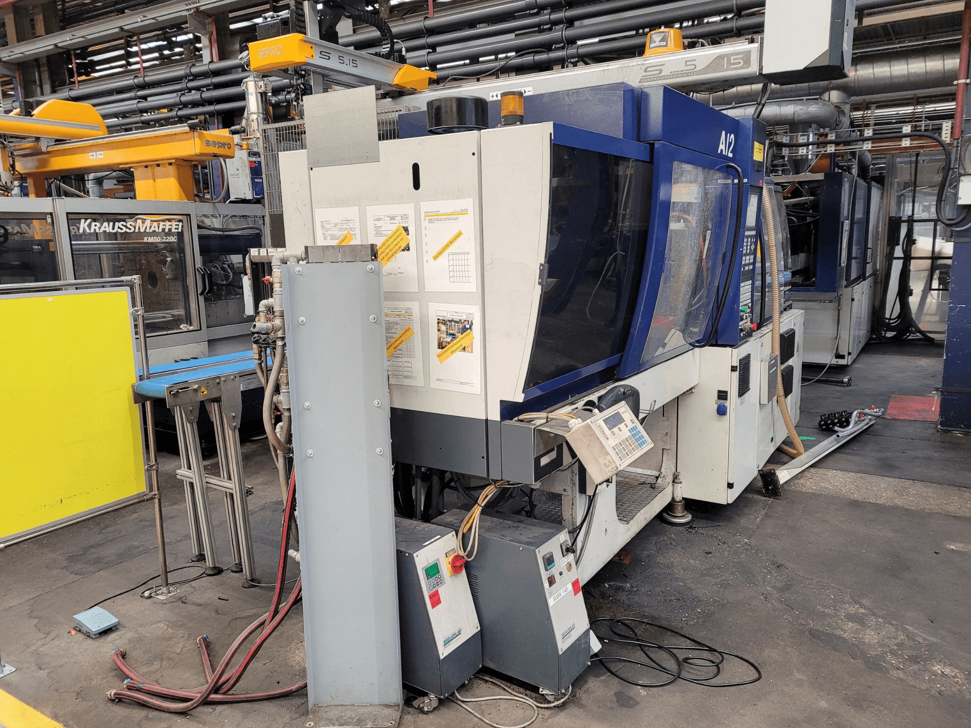 Термопластавтомат KraussMaffei моделі KM80-232G, вигляд спереду, з панеллю керування та робочими компонентами.