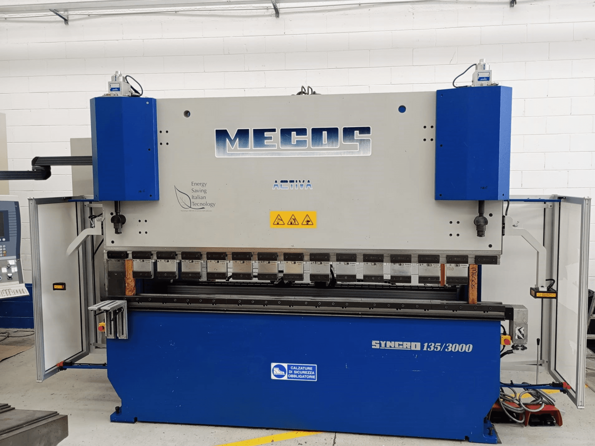 Вид спереду листозгинального преса MECOS SYNCRO 135/3000, демонструє елементи керування, інструменти для згинання та засоби безпеки.