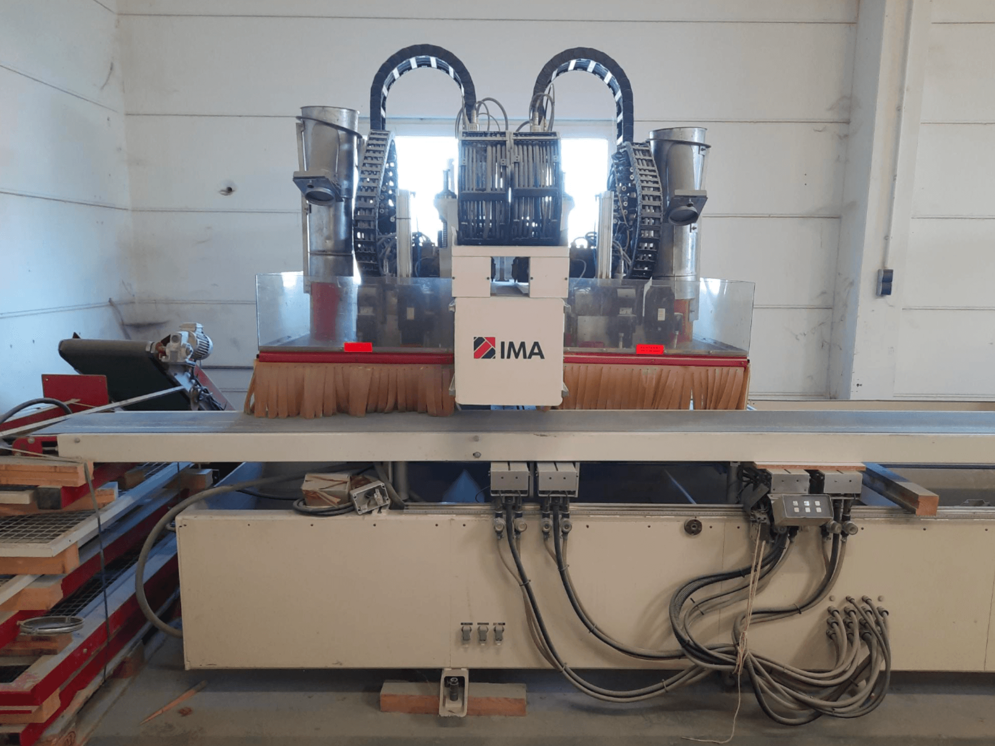 Центр обробки деревини з ЧПУ IMA BIMA 610 V, зображений у фронтальному ракурсі, з щітками, елементами управління та робочим столом.