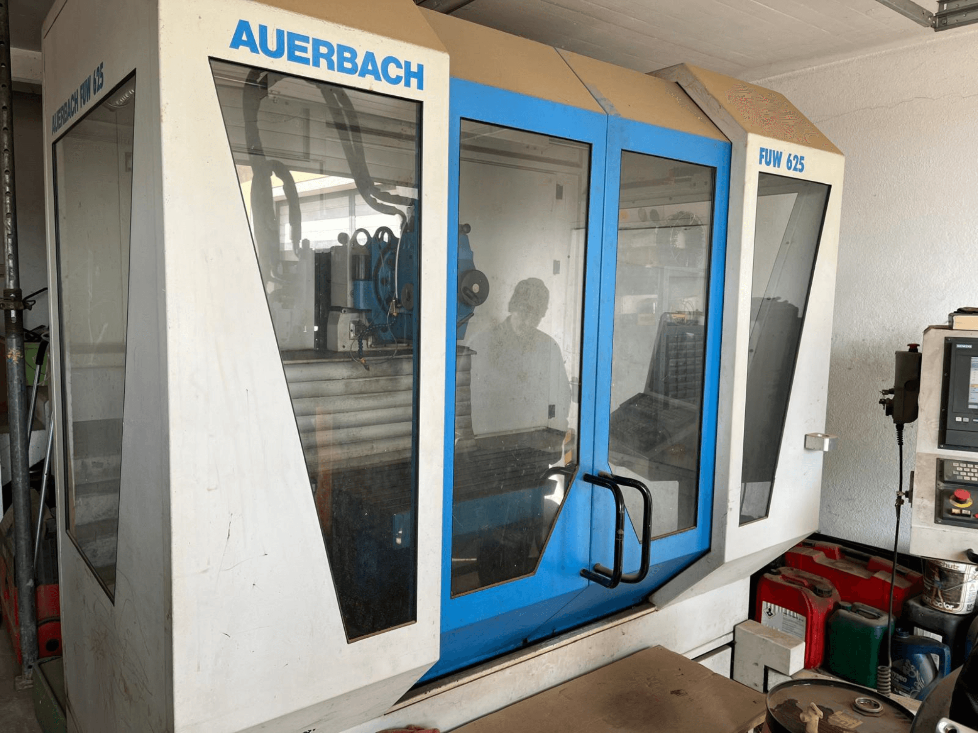 Універсальний обробний центр Auerbach FUW 625 у вигляді збоку, зі скляними панелями та панеллю керування праворуч.