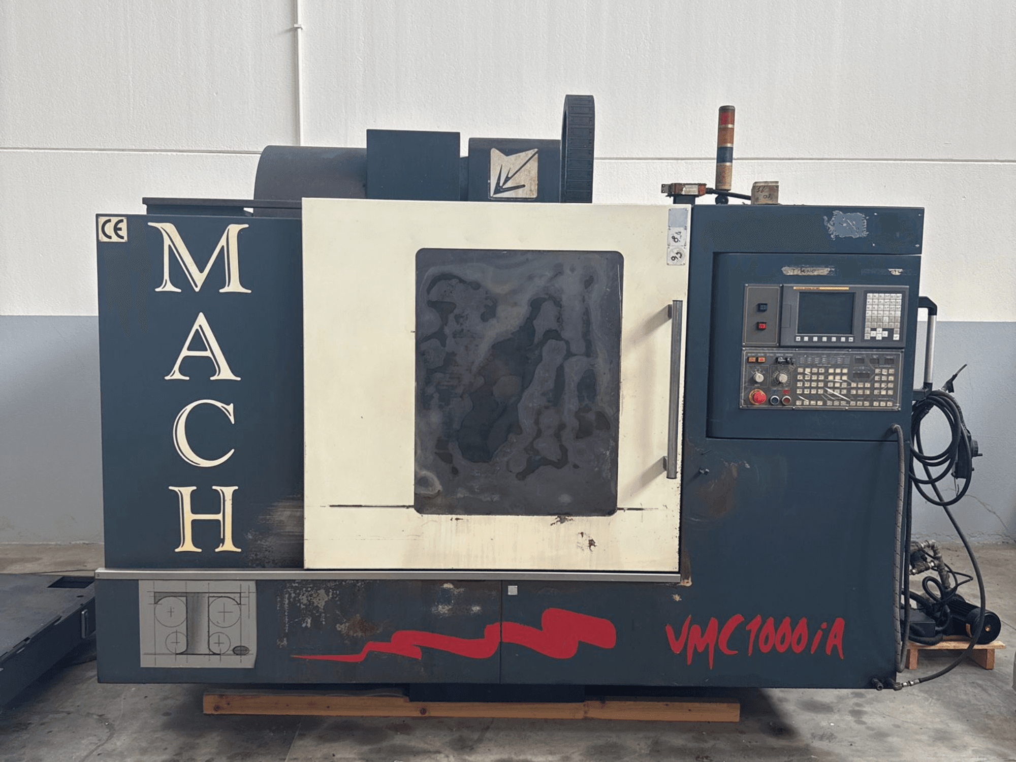 Вертикальний обробний центр MIND MACH VMC 1000/A спереду, з панеллю керування, шпинделем та розміткою основи.