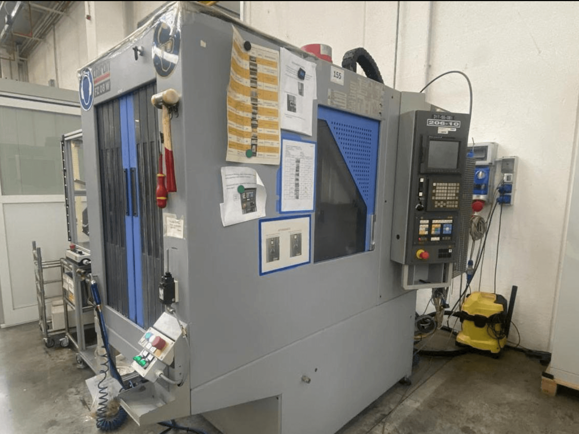 Верстат з ЧПК Shin Lin, вид спереду, з панеллю керування, кнопками керування та інструкцією з техніки безпеки.