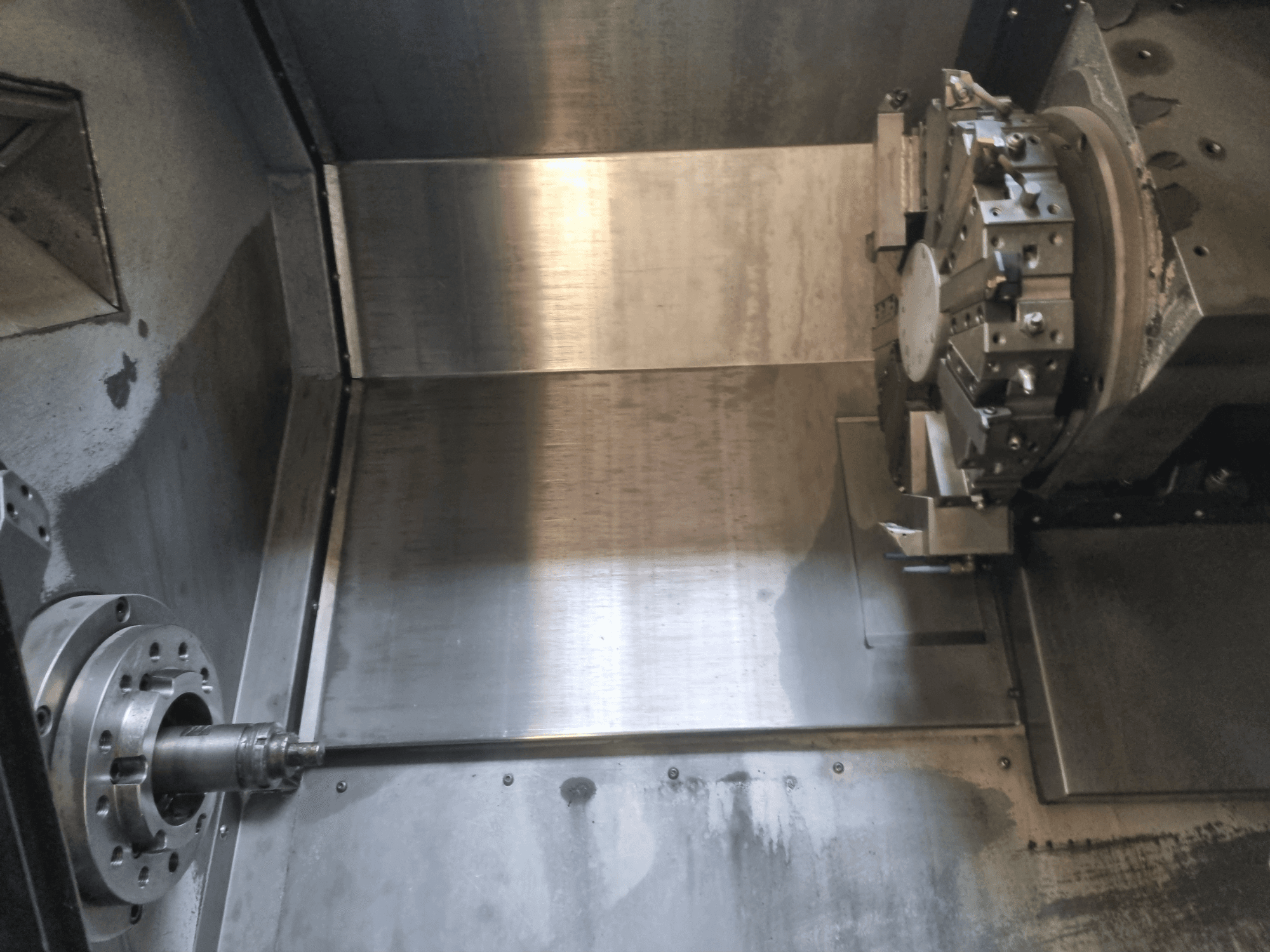 Внутрішній вигляд токарного верстата з ЧПУ, з обертовим шпинделем і металевою робочою поверхнею, що демонструє промислову точність інженерії.