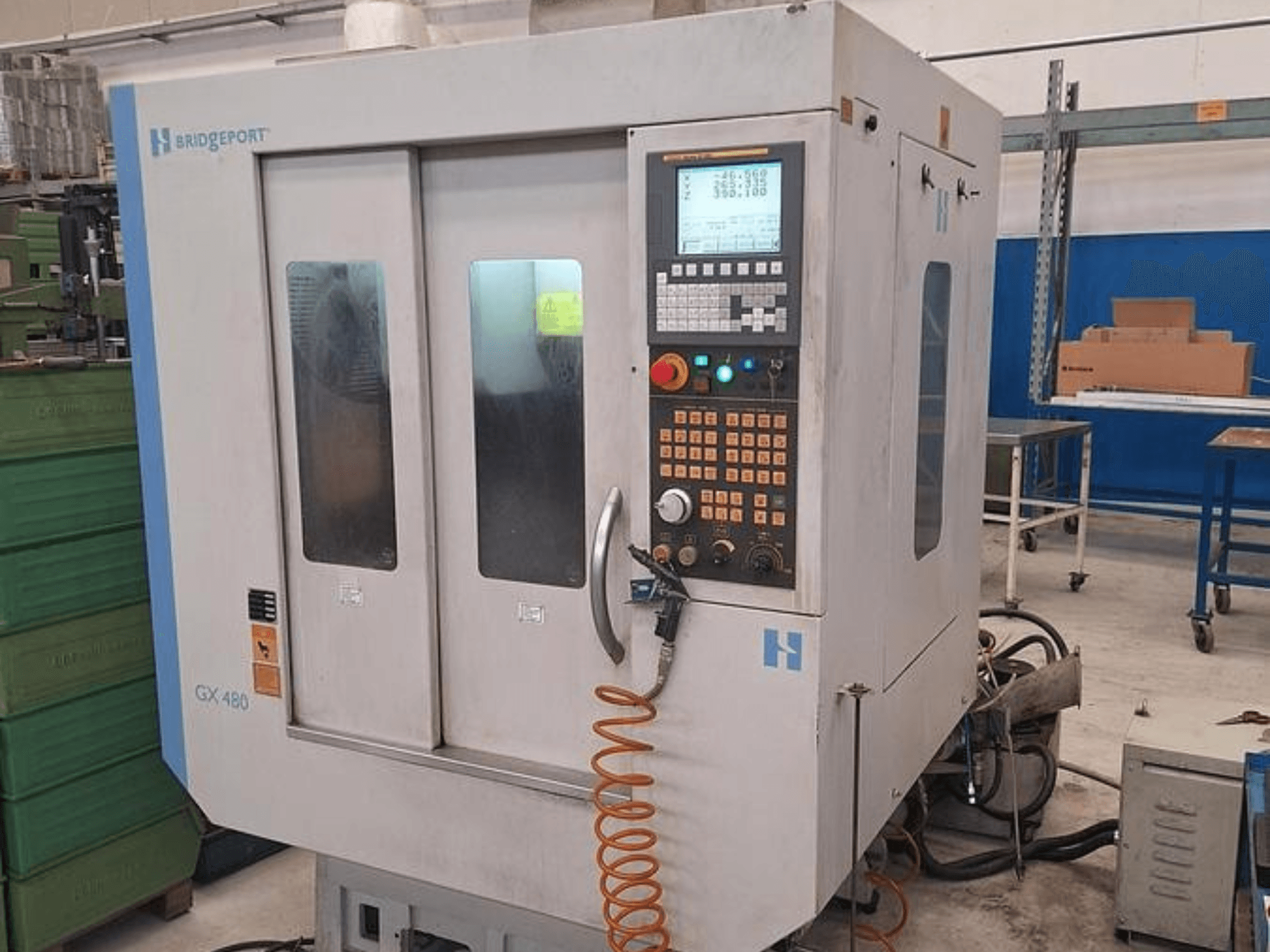Вертикальний обробний центр Bridgeport GX 480 спереду, з панеллю керування, подвійними скляними дверима та гнучким шлангом.